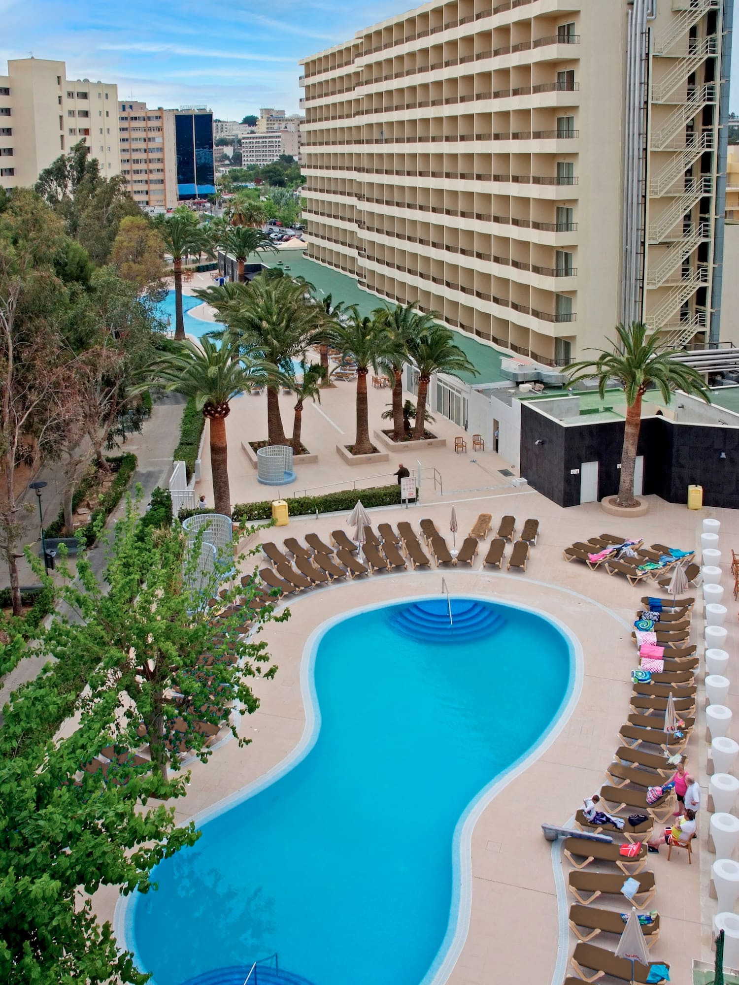 a pool with lounge chairs and palm trees