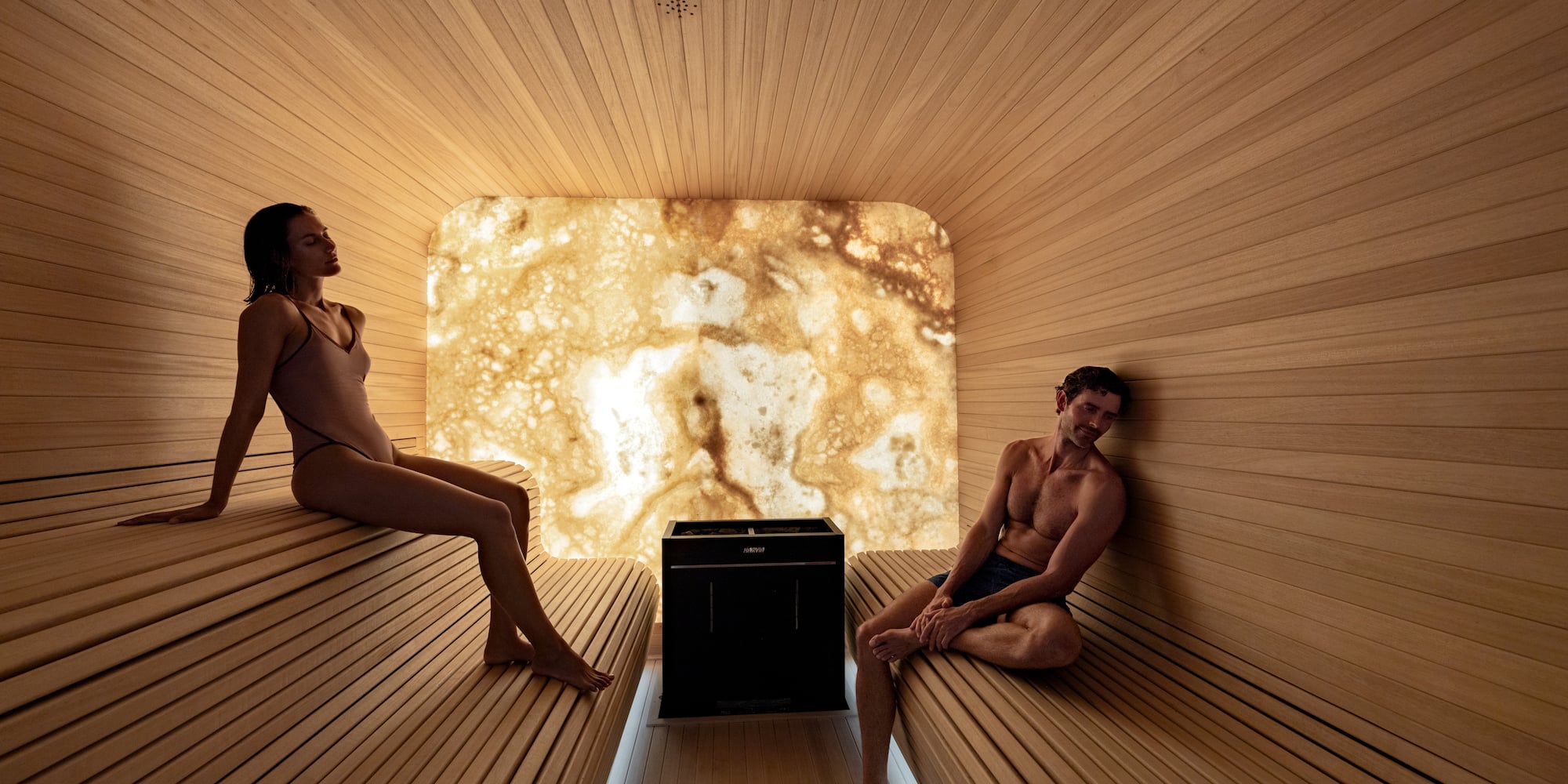 a man and woman sitting in a sauna
