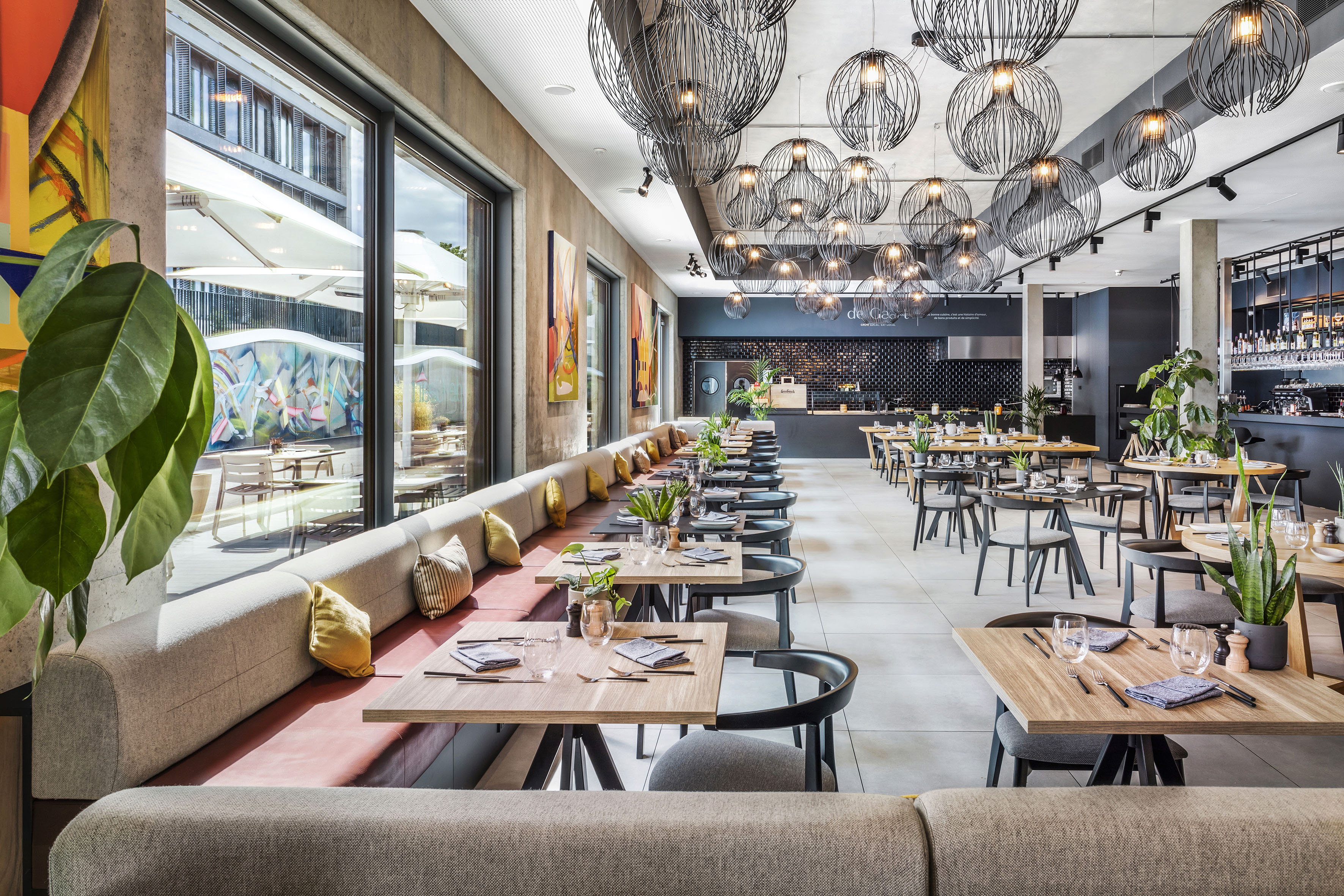 Modern restaurant dining with banquette seating and sphere pendant lights. - INNSiDE Luxembourg, Люксембург
