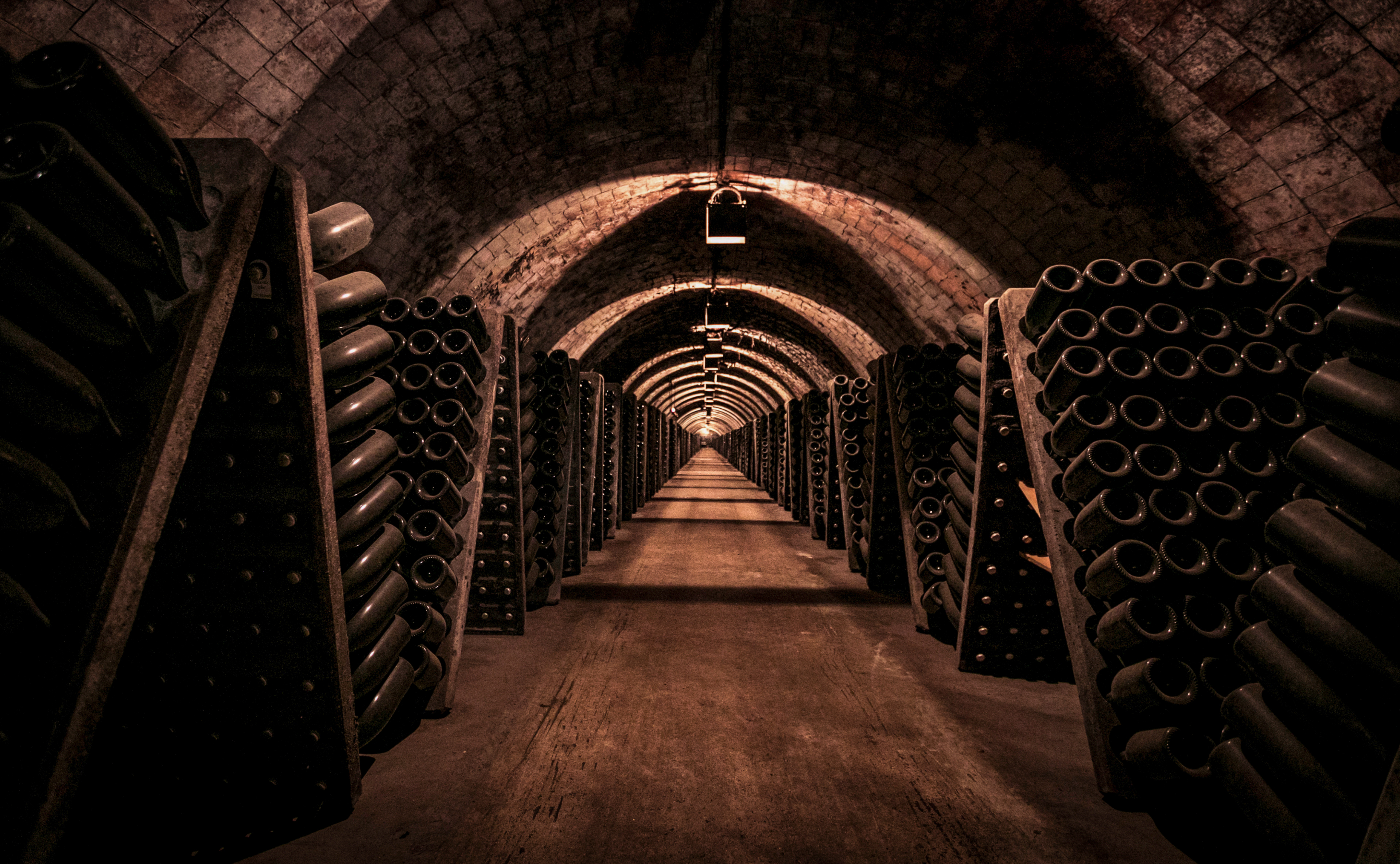 a tunnel with rows of wine bottles