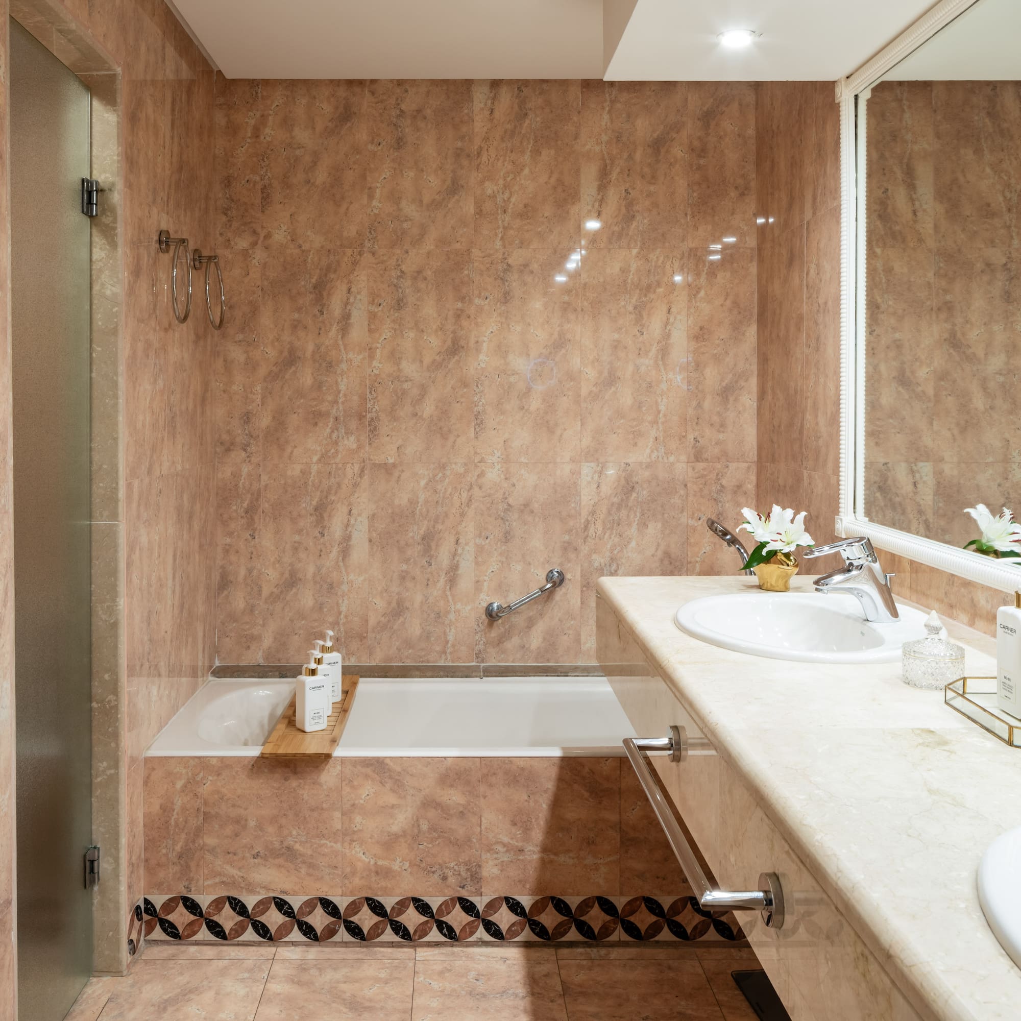 a bathroom with marble walls and a sink and bathtub
