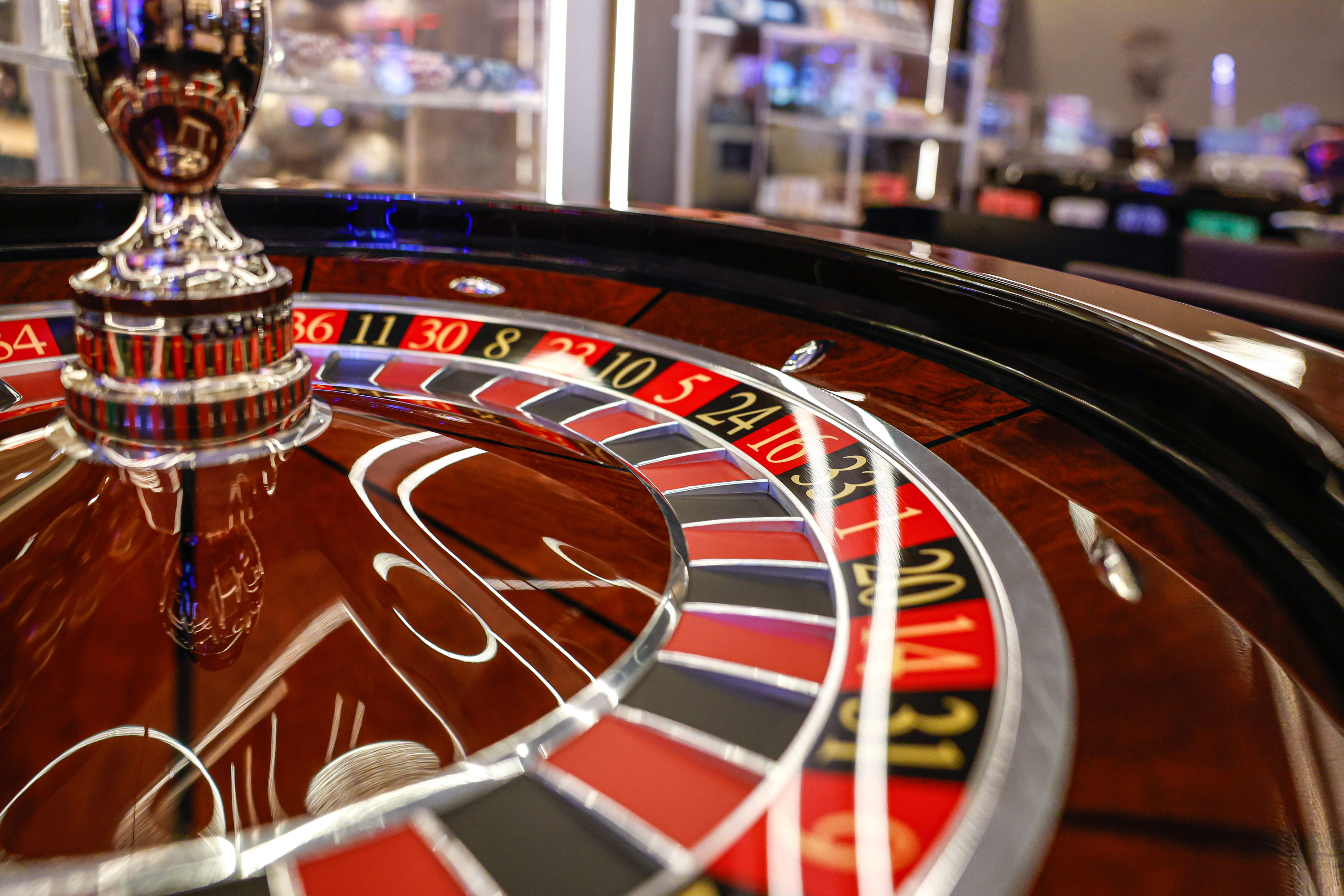 Close-up of a glossy roulette wheel with red and black numbers in a casino.