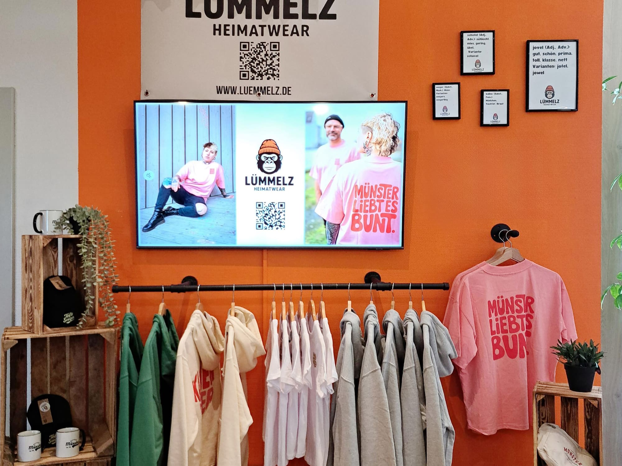 a room with a tv and clothes on the wall