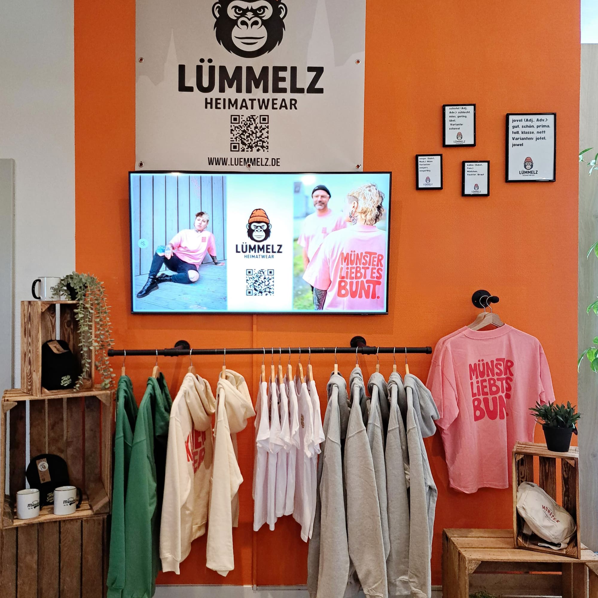 a room with a tv and clothes on the wall