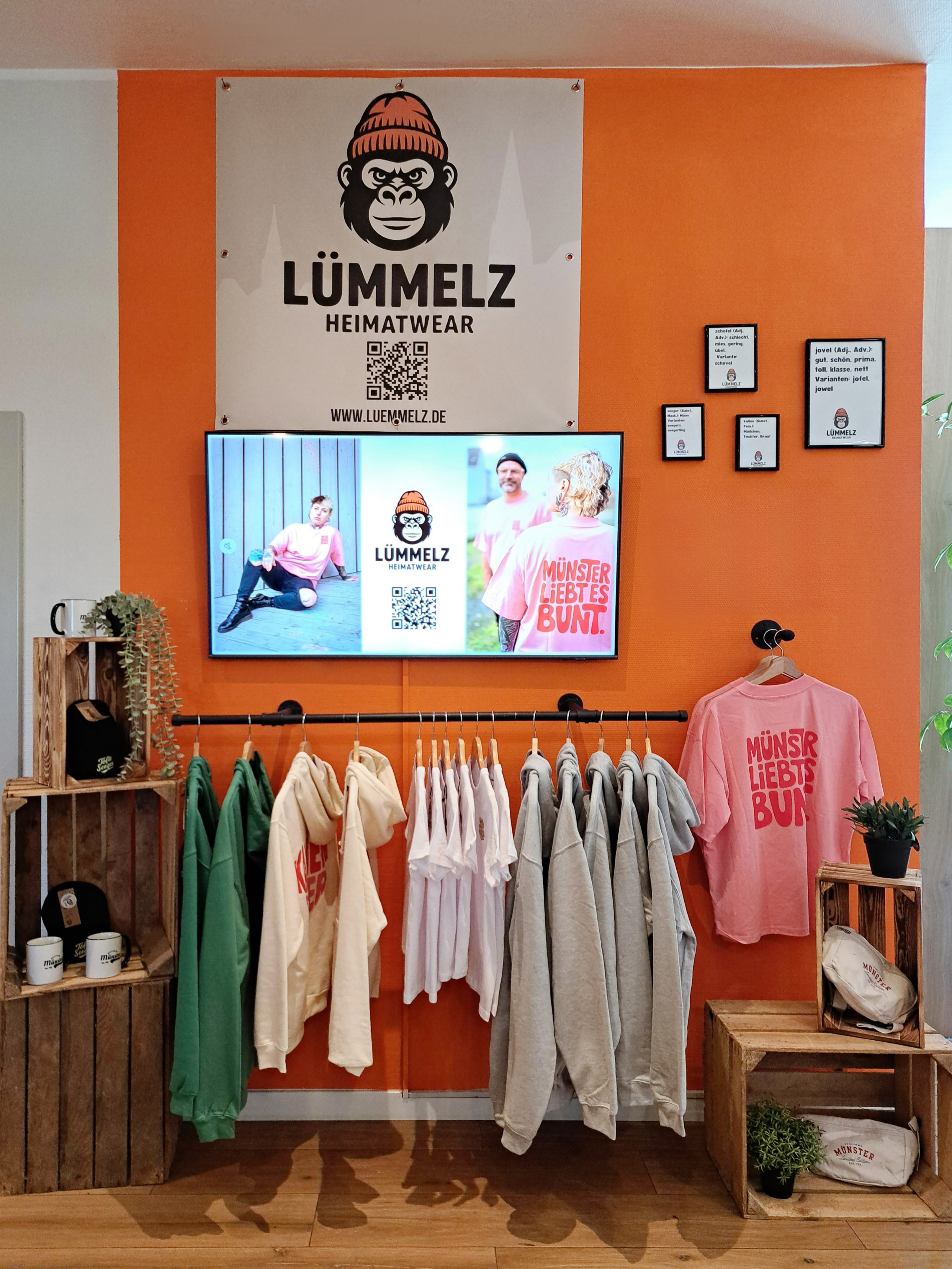 a room with a tv and clothes on the wall