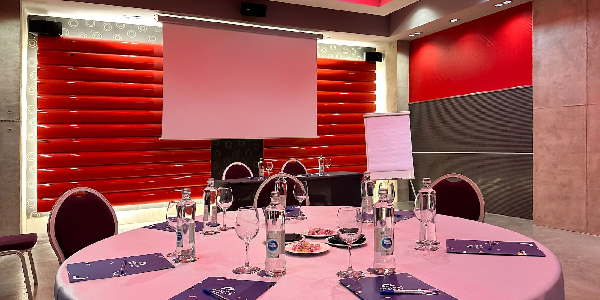 a round table with a pink tablecloth and glasses on it