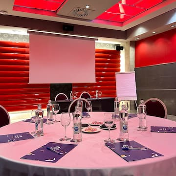 a round table with a pink tablecloth and glasses on it
