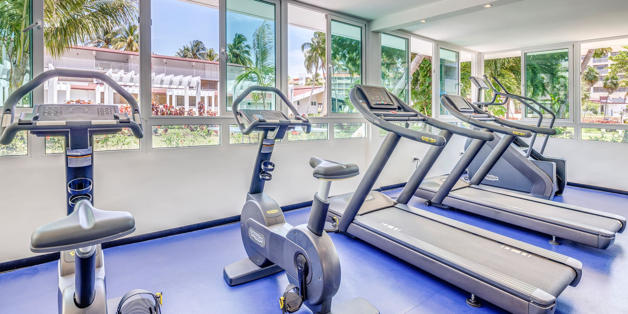 a room with exercise machines and windows