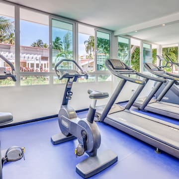 a room with exercise machines and windows