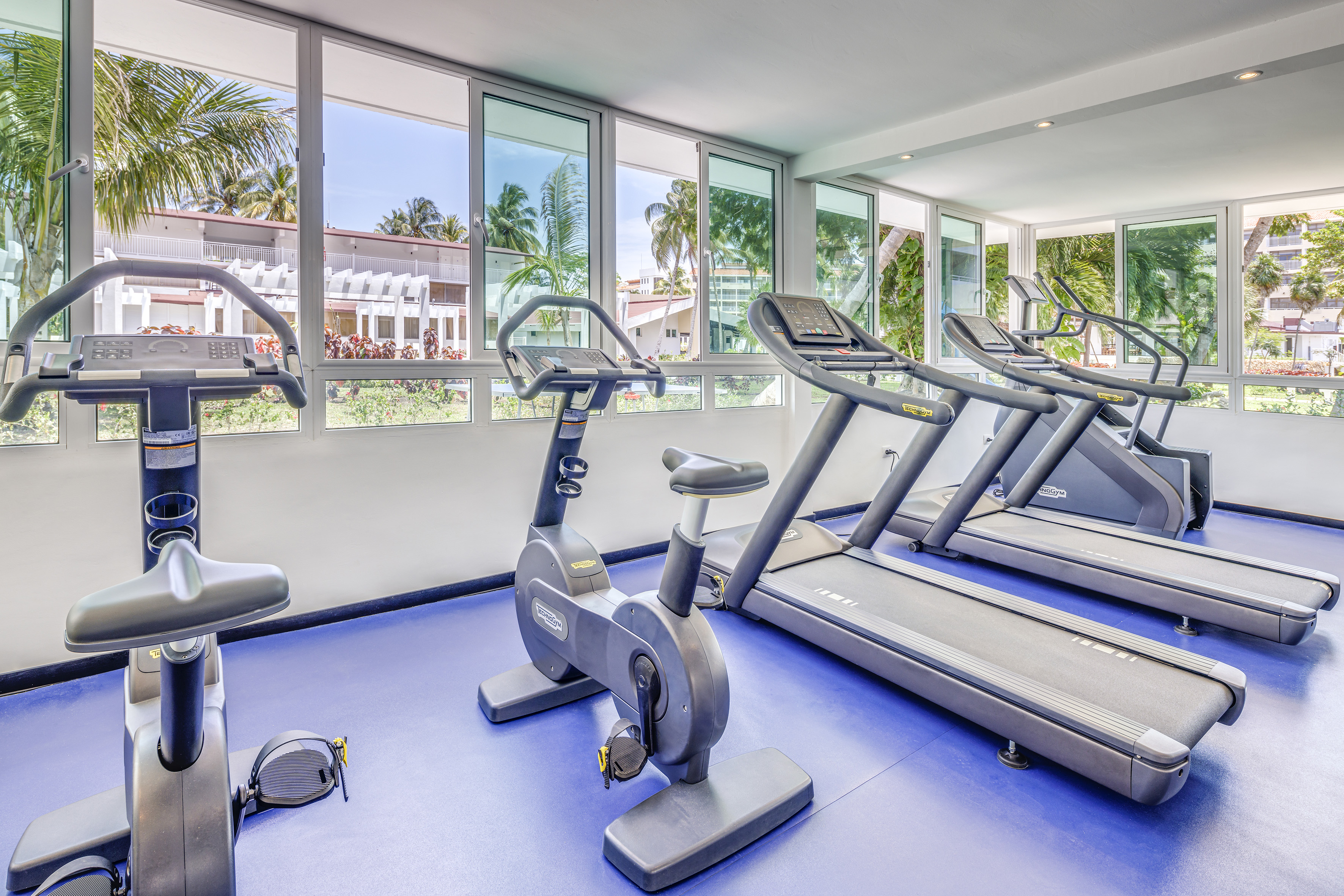 a room with exercise machines and windows