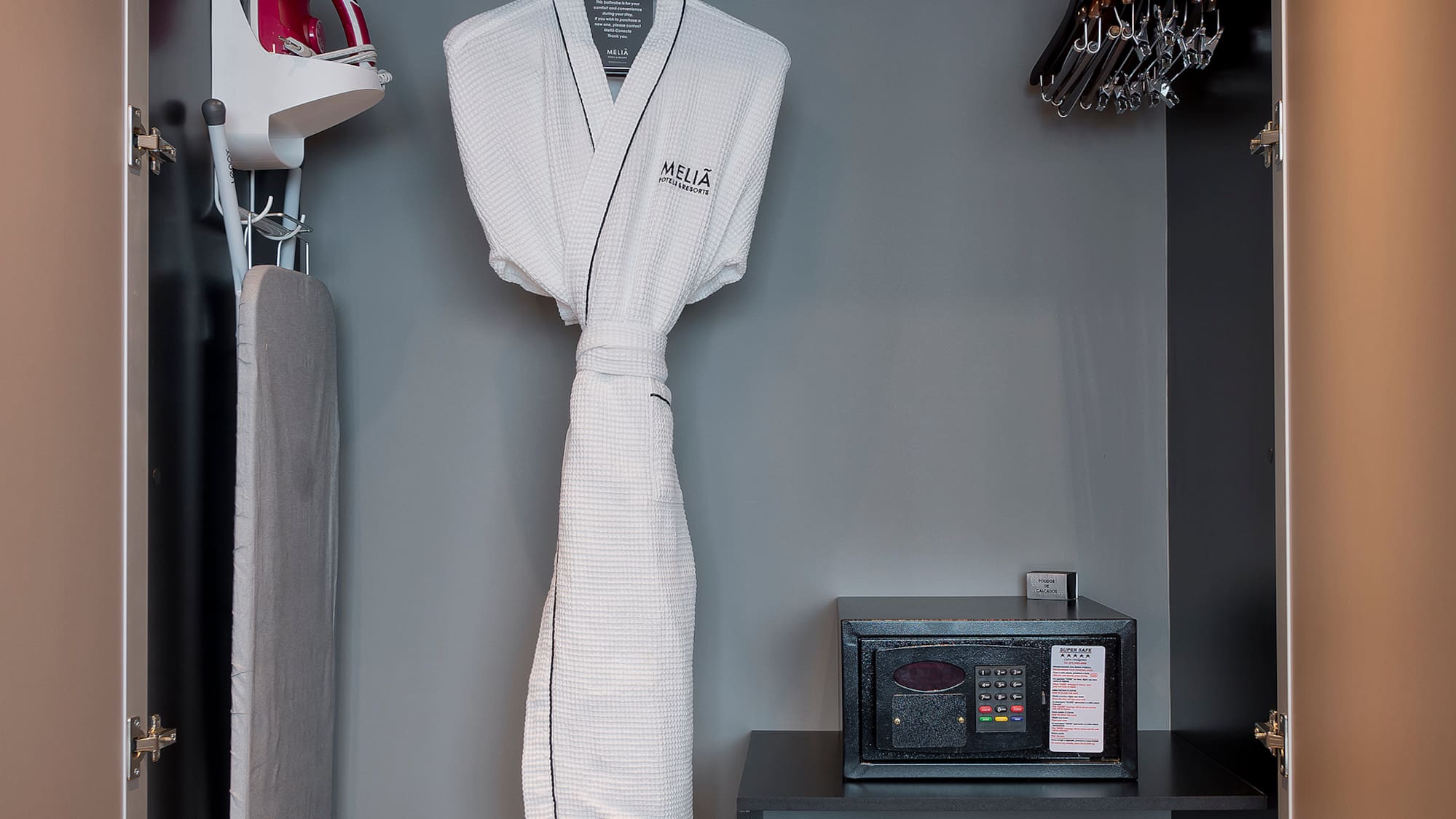 a closet with a white robe and irons