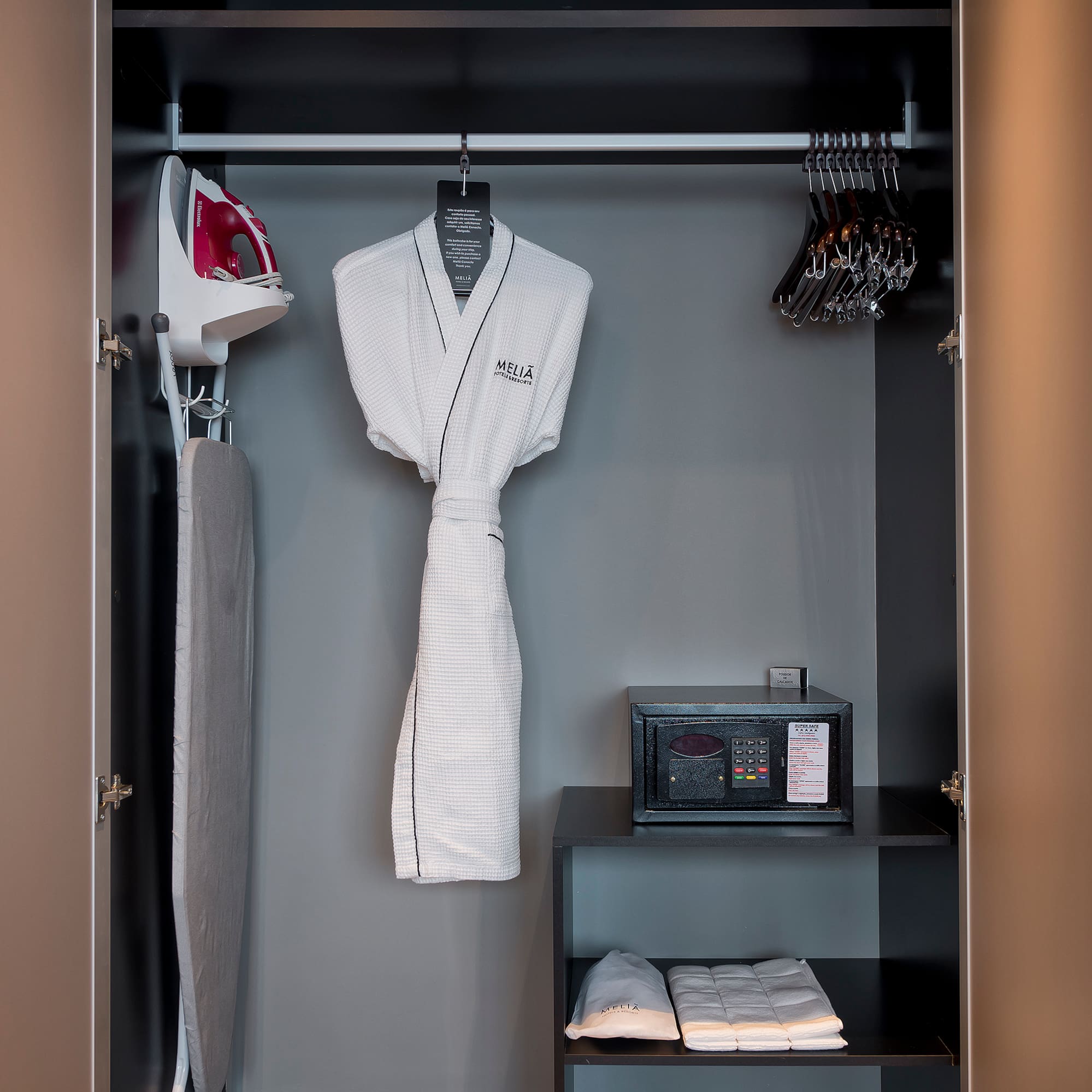 a closet with a white robe and irons