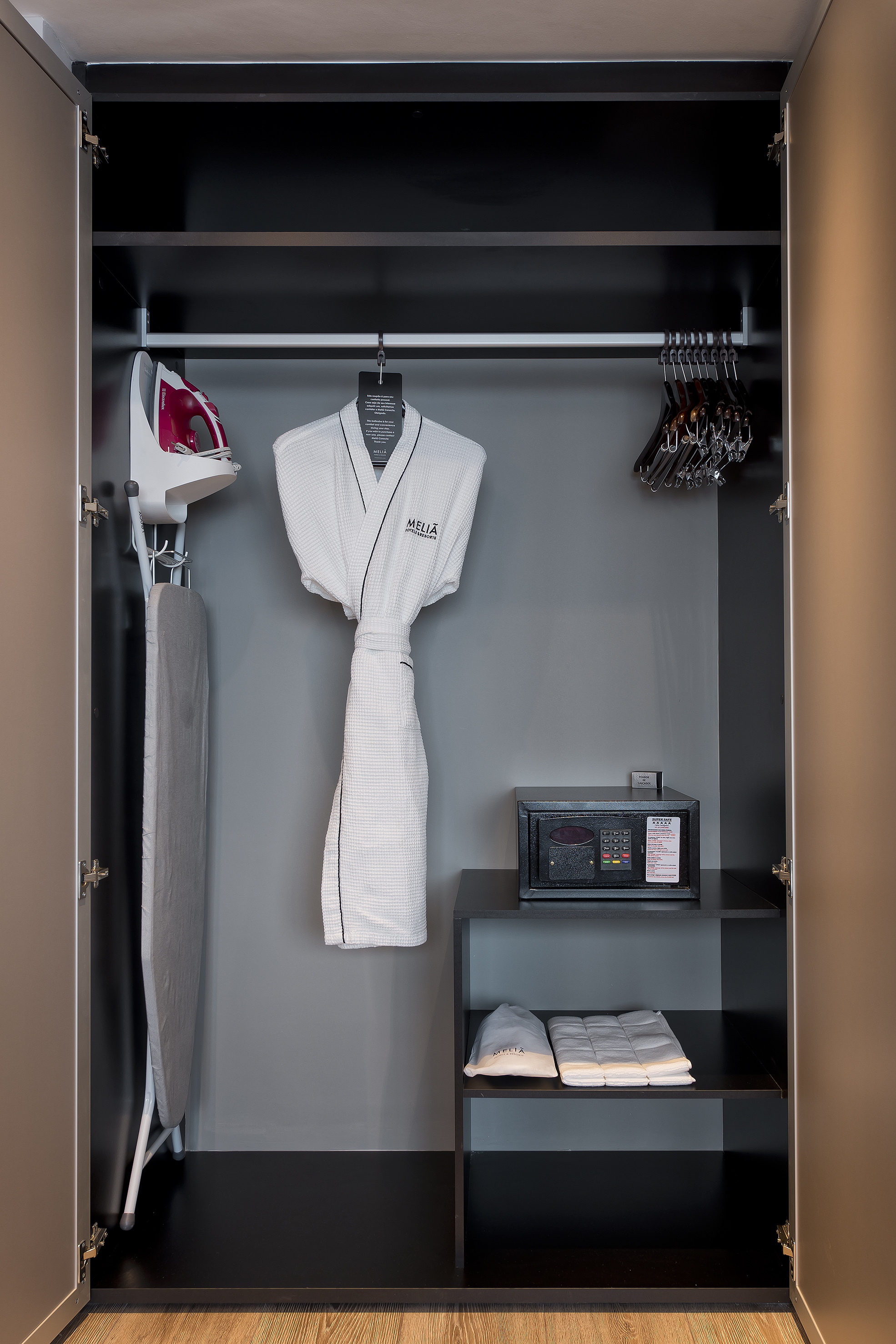 Meliá hotel wardrobe with iron, board, bathrobe, hangers, and security safe.