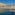 a body of water with a body of water and a city with palm trees