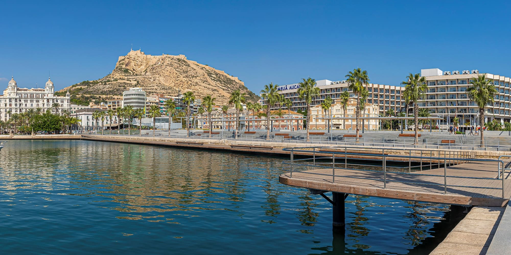 a body of water with a body of water and a city with palm trees