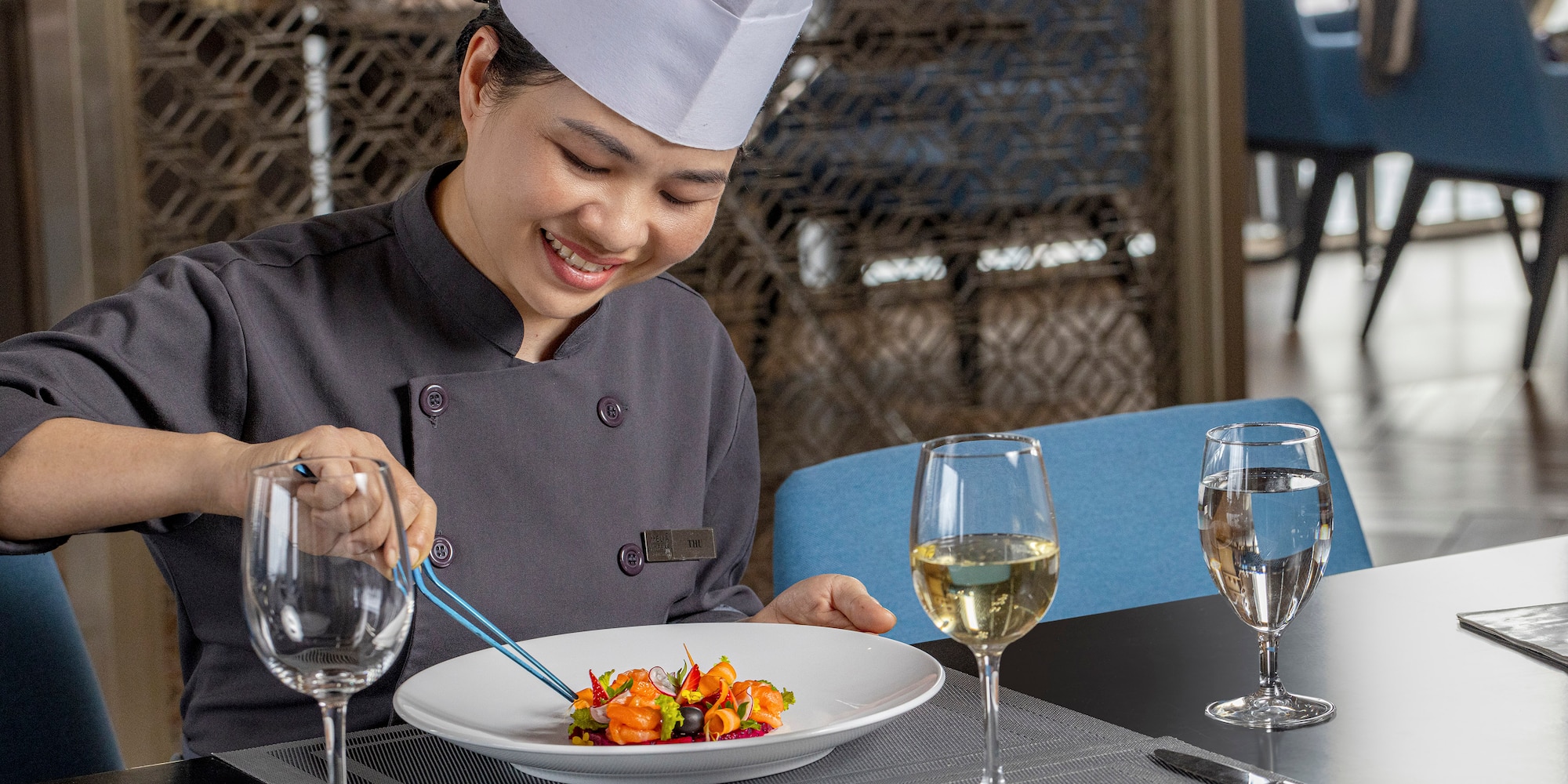 a woman in a chef's hat and white hat preparing food