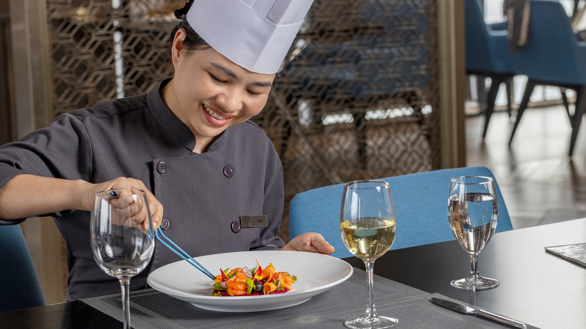 a woman in a chef's hat and white hat preparing food
