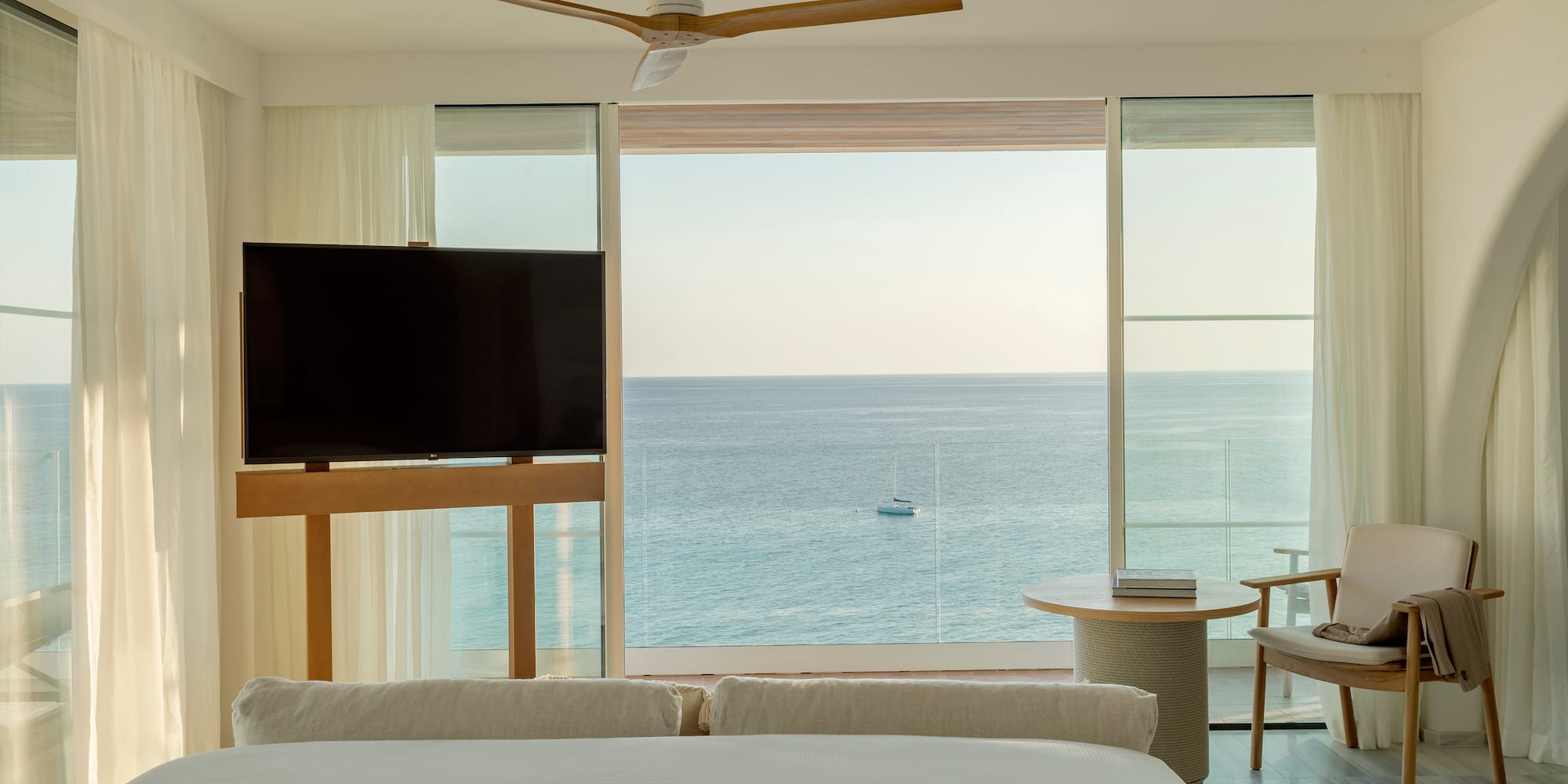 a room with a television and a view of the ocean