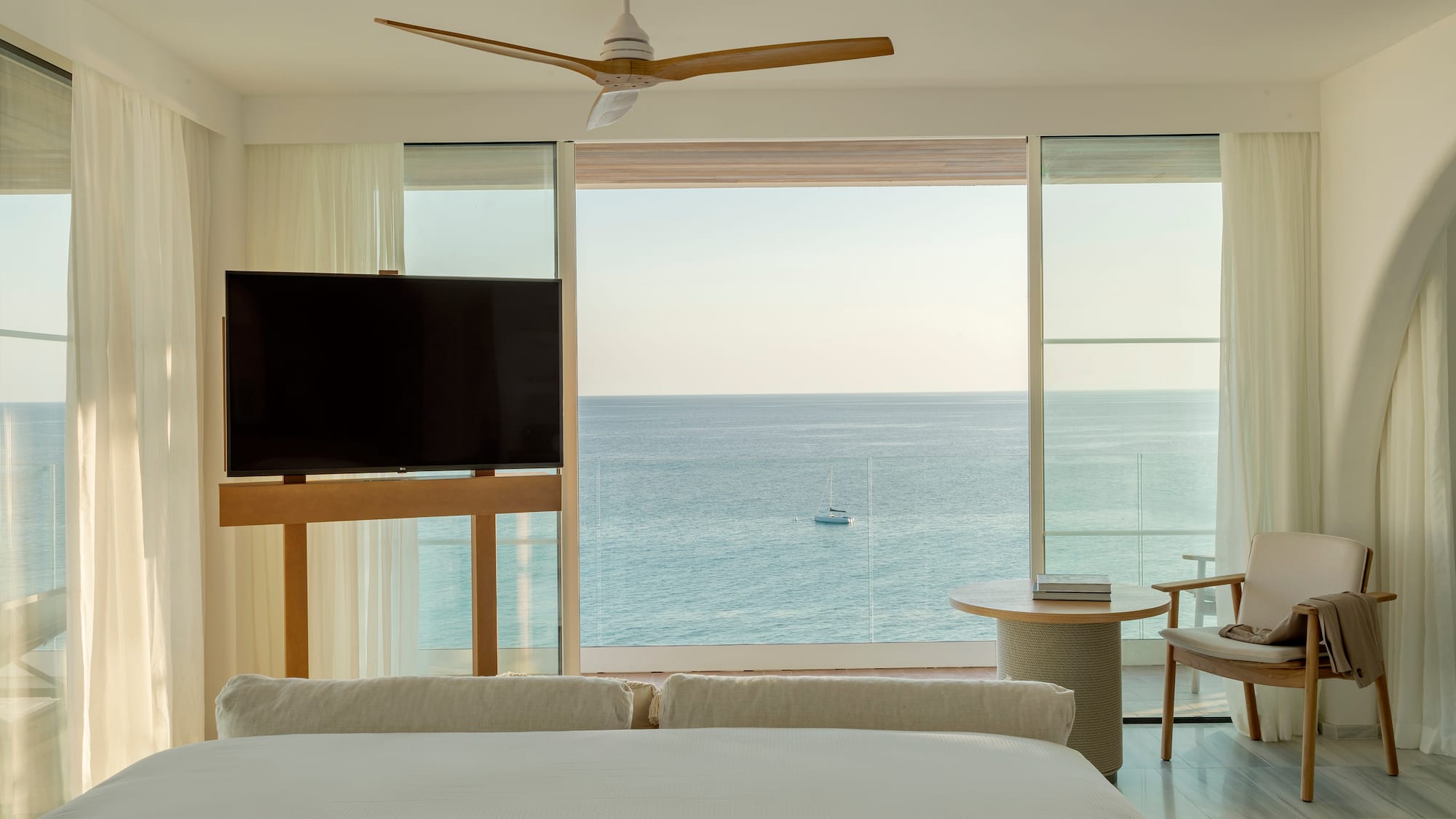 a room with a television and a view of the ocean