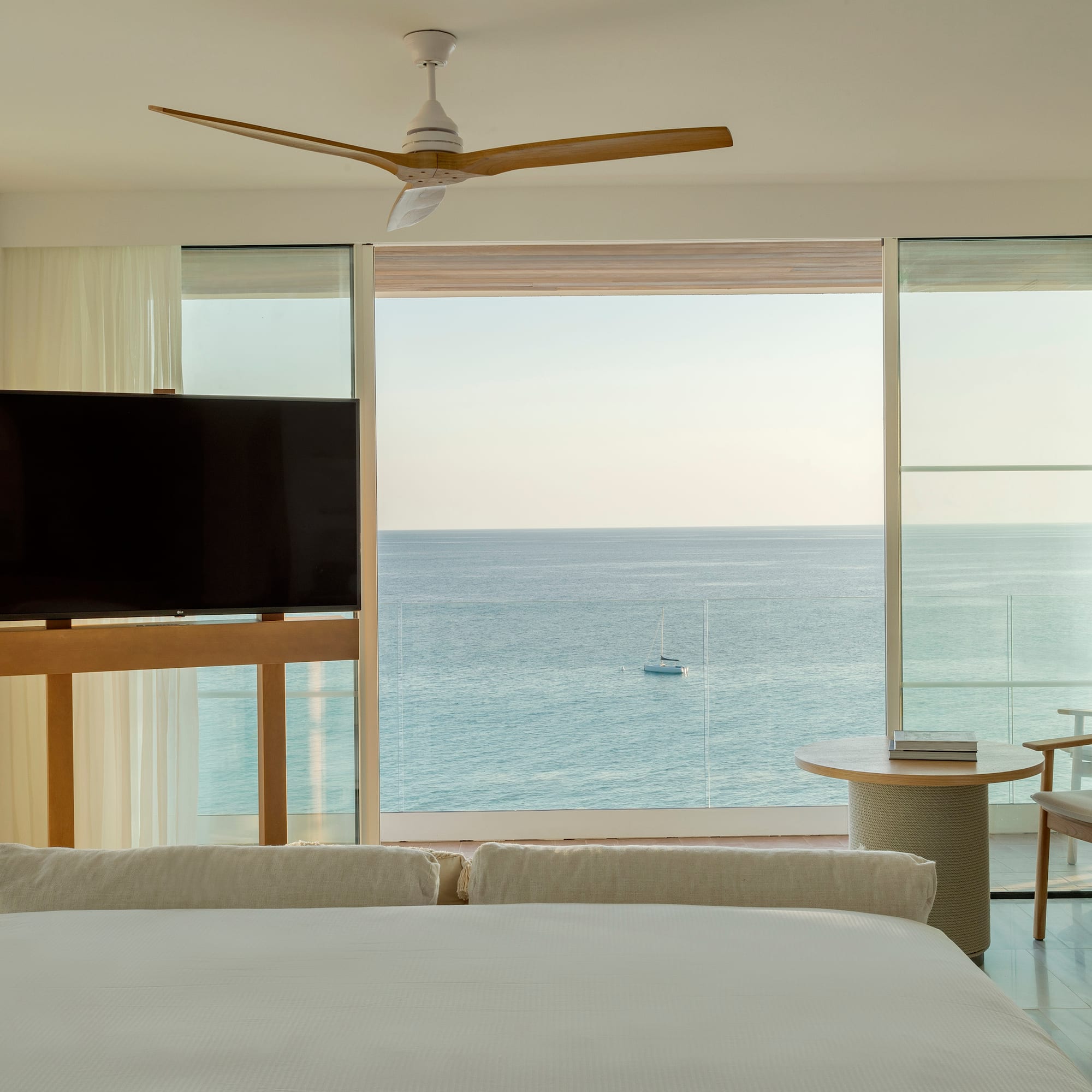a room with a television and a view of the ocean