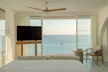 a room with a television and a view of the ocean