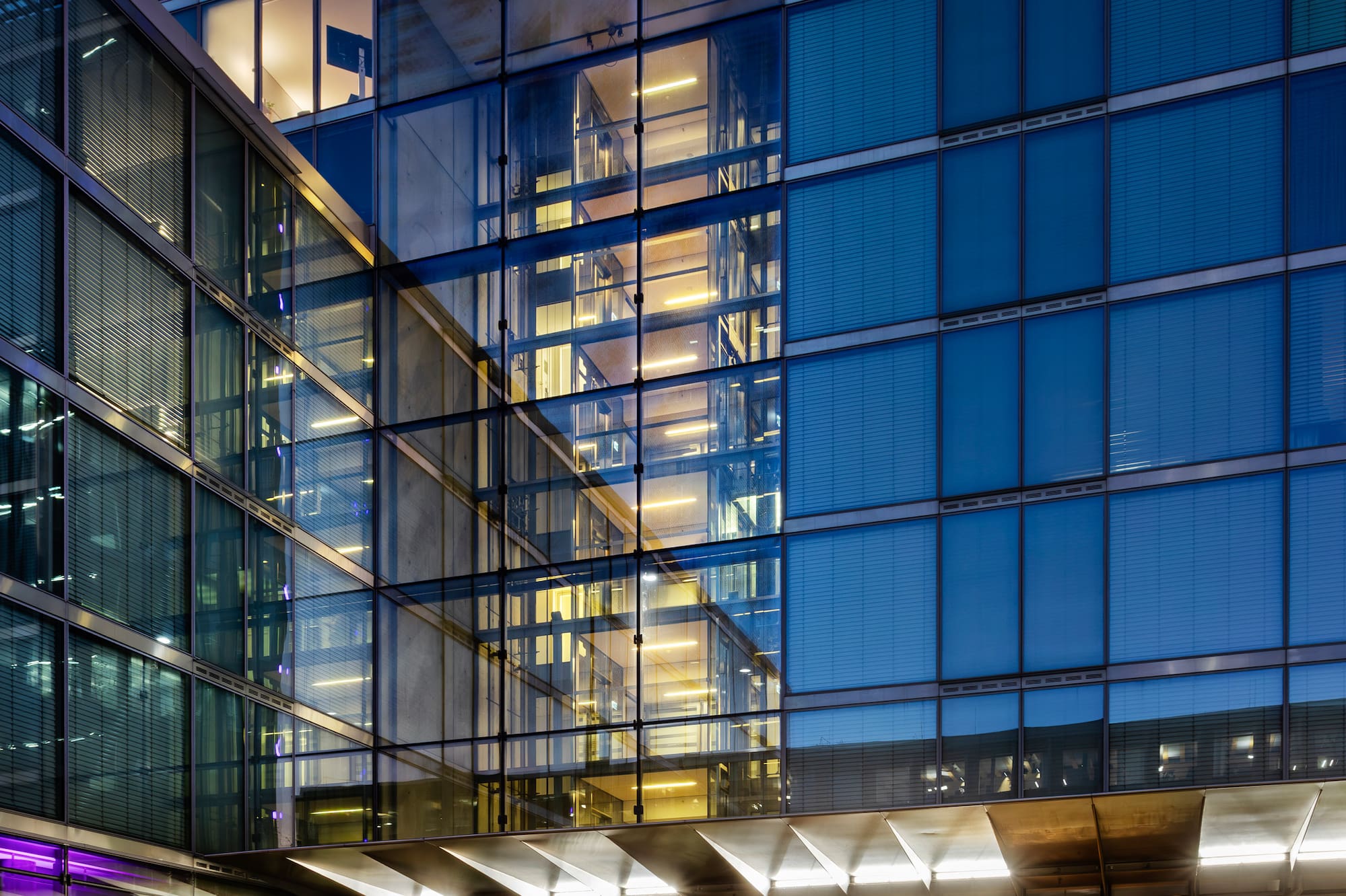 Modern glass hotel building entrance at night, showing "INNSiDE by MELIA" sign.