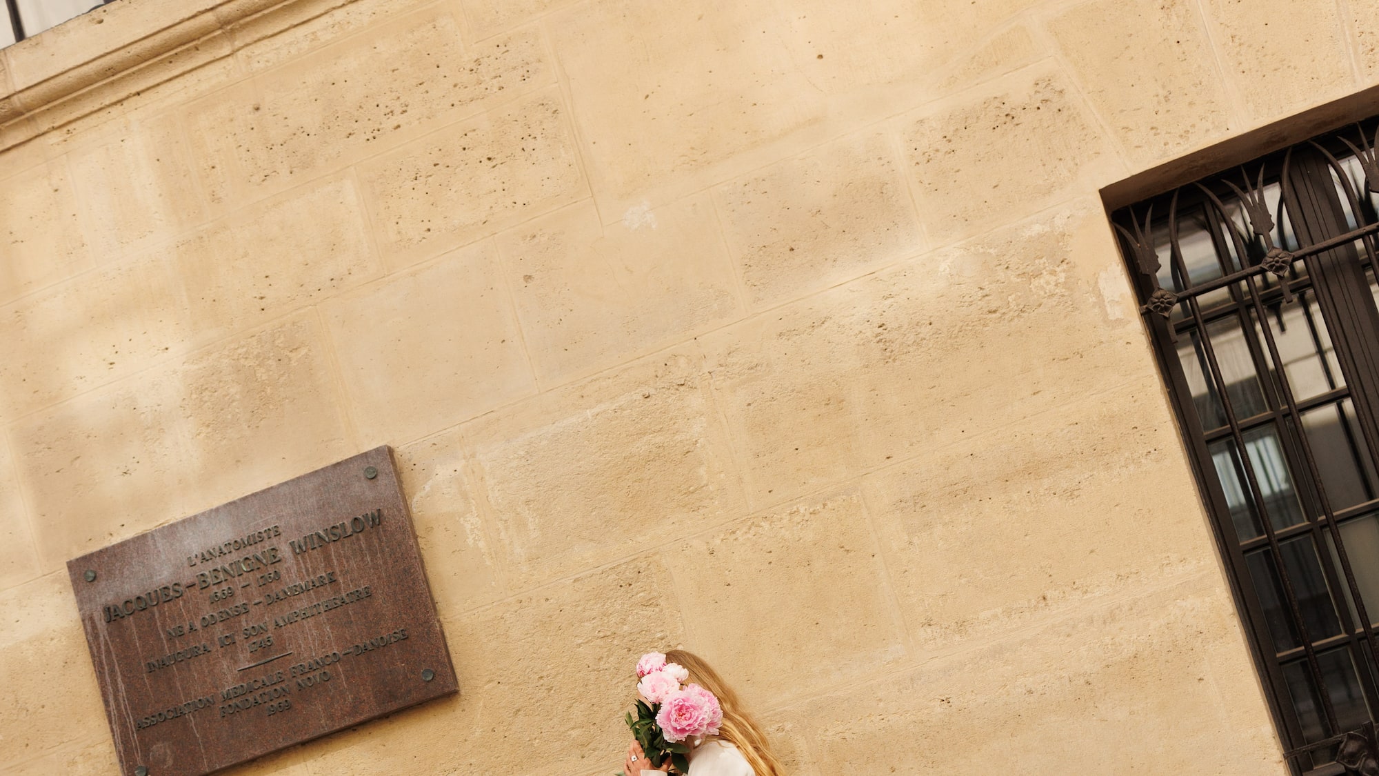 a woman in white dress holding flowers