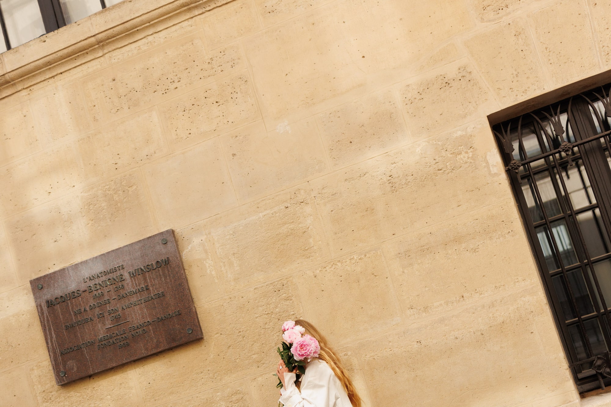 a woman in white dress holding flowers