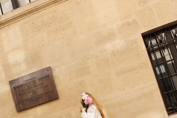 a woman in white dress holding flowers