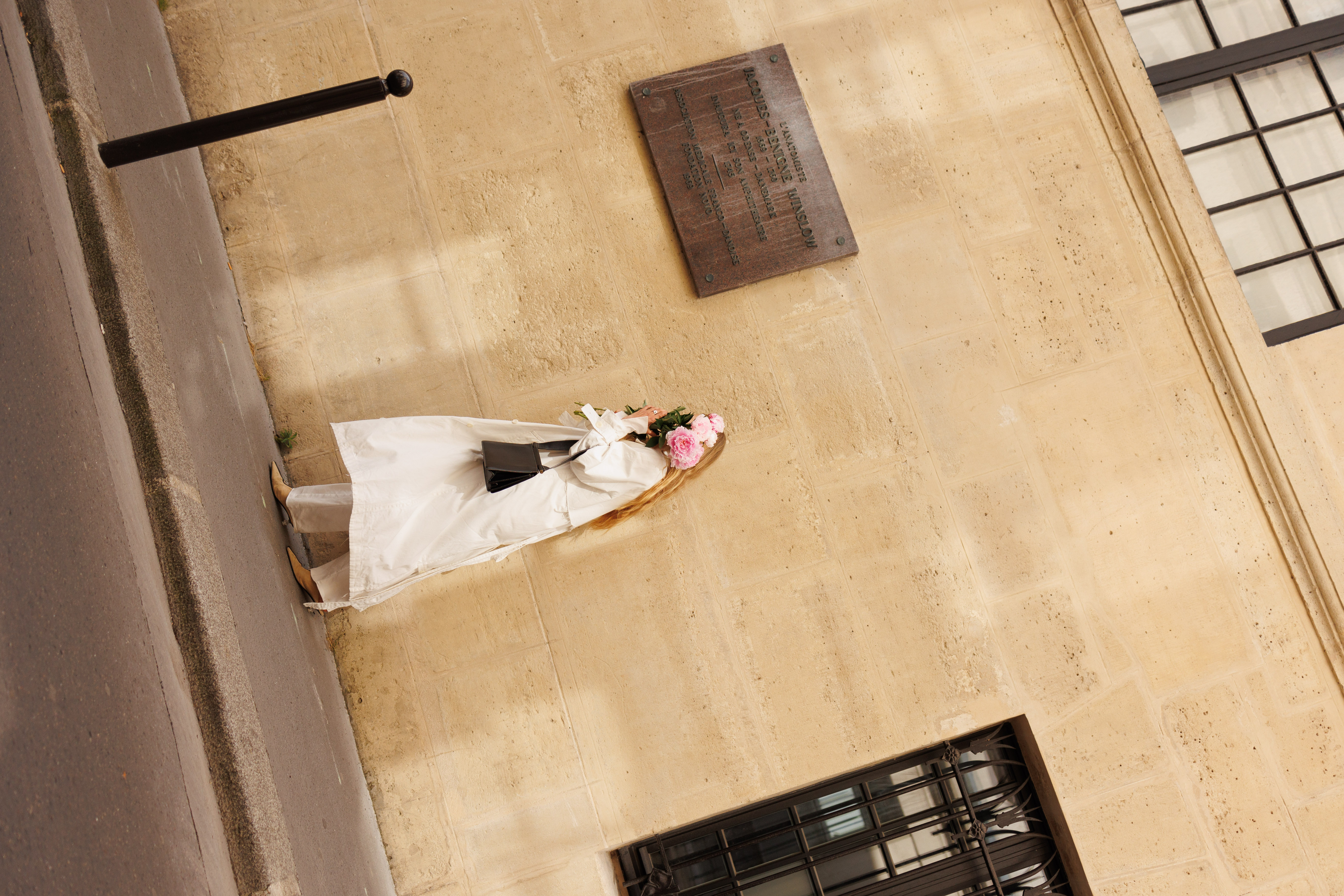 a woman in white dress holding flowers