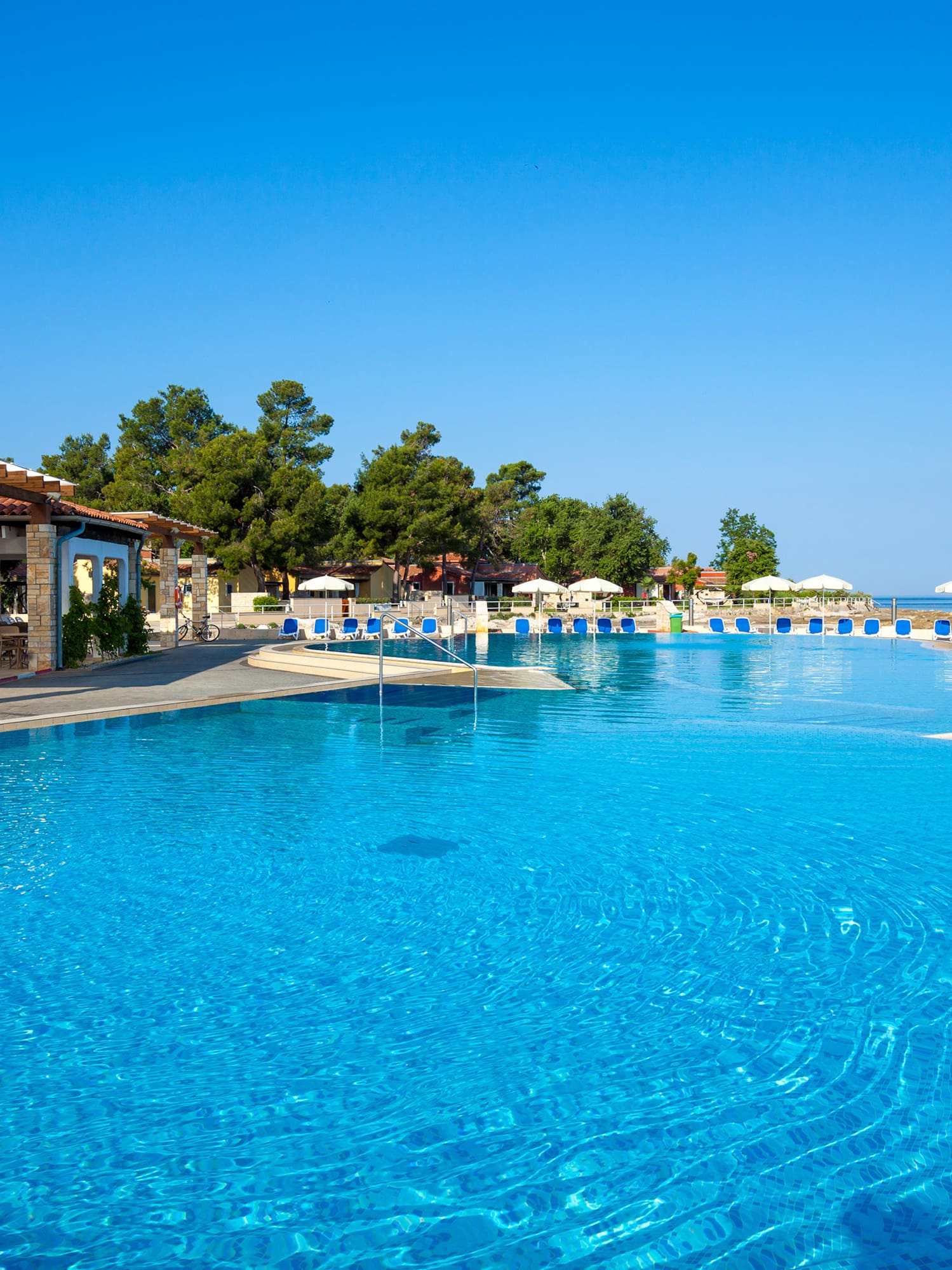 a pool with chairs and umbrellas