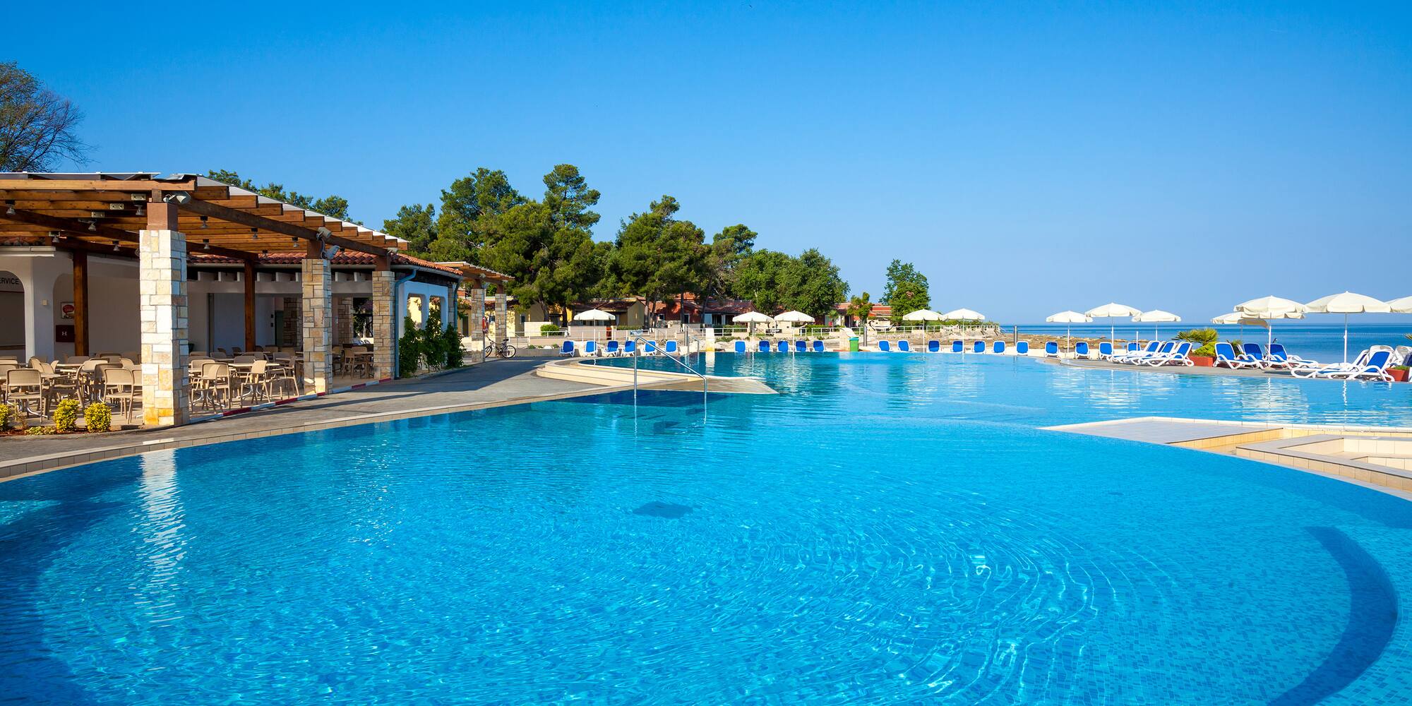 a pool with chairs and umbrellas