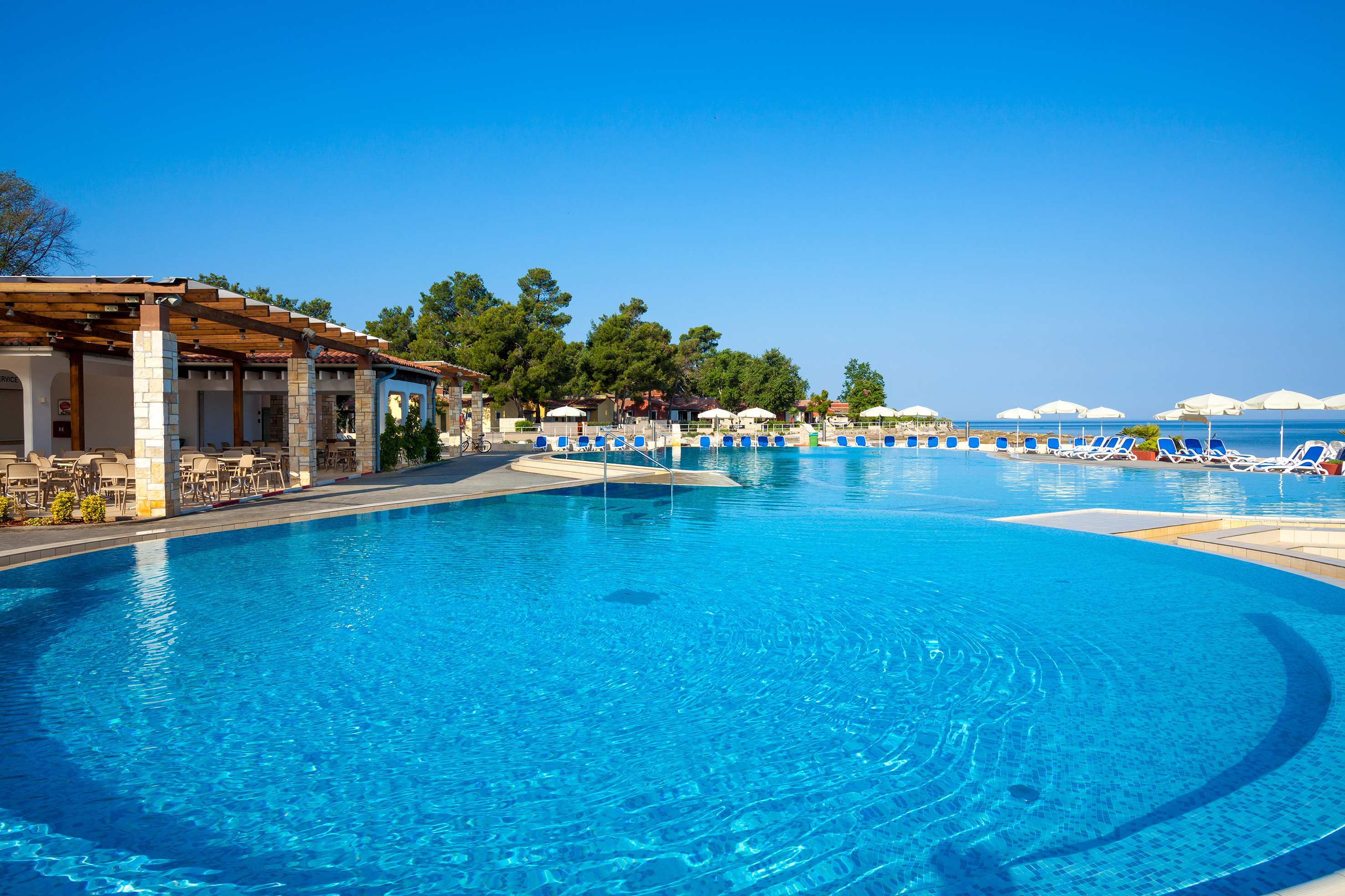 a pool with chairs and umbrellas