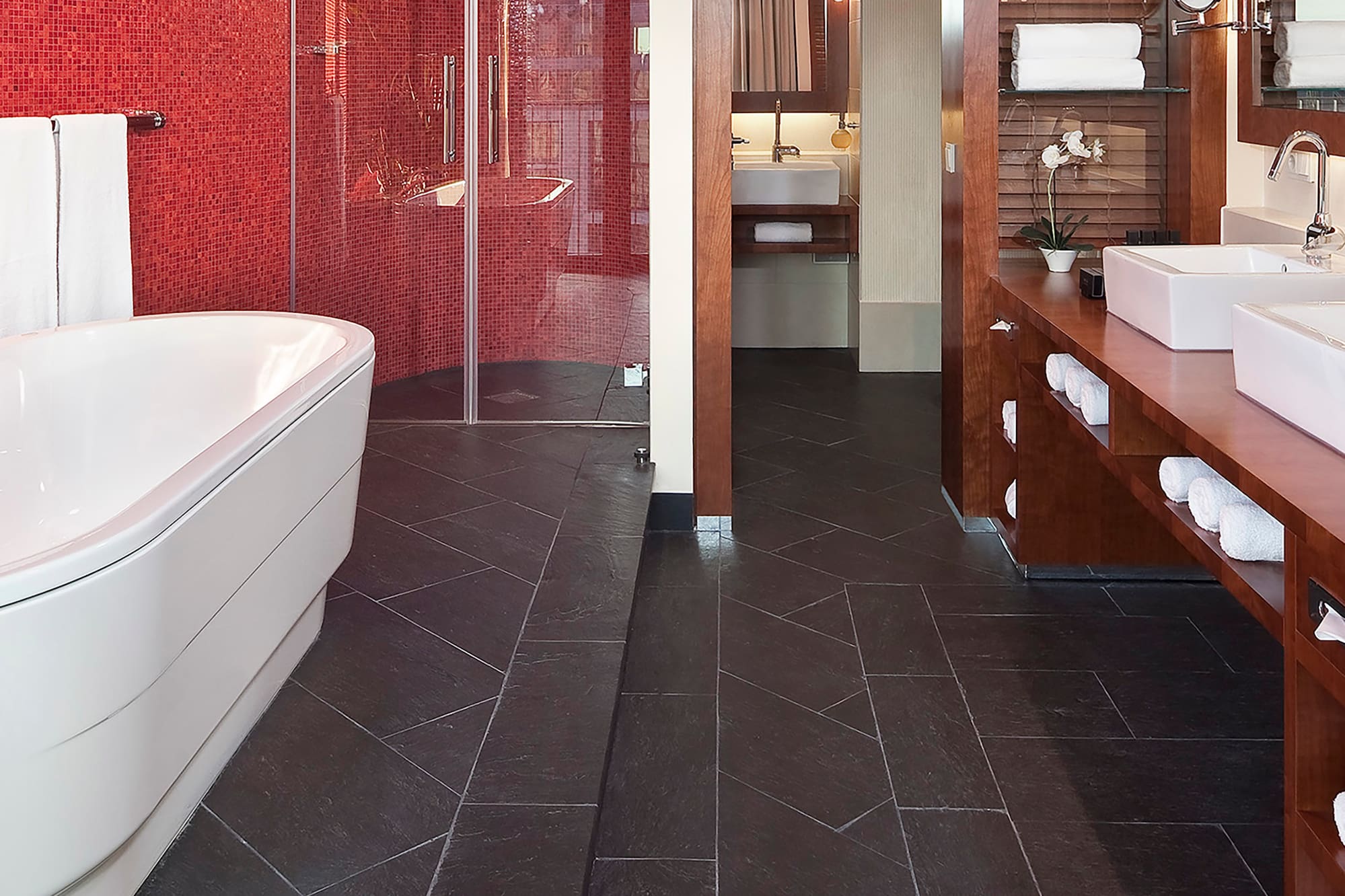 a bathroom with a red wall and a tub
