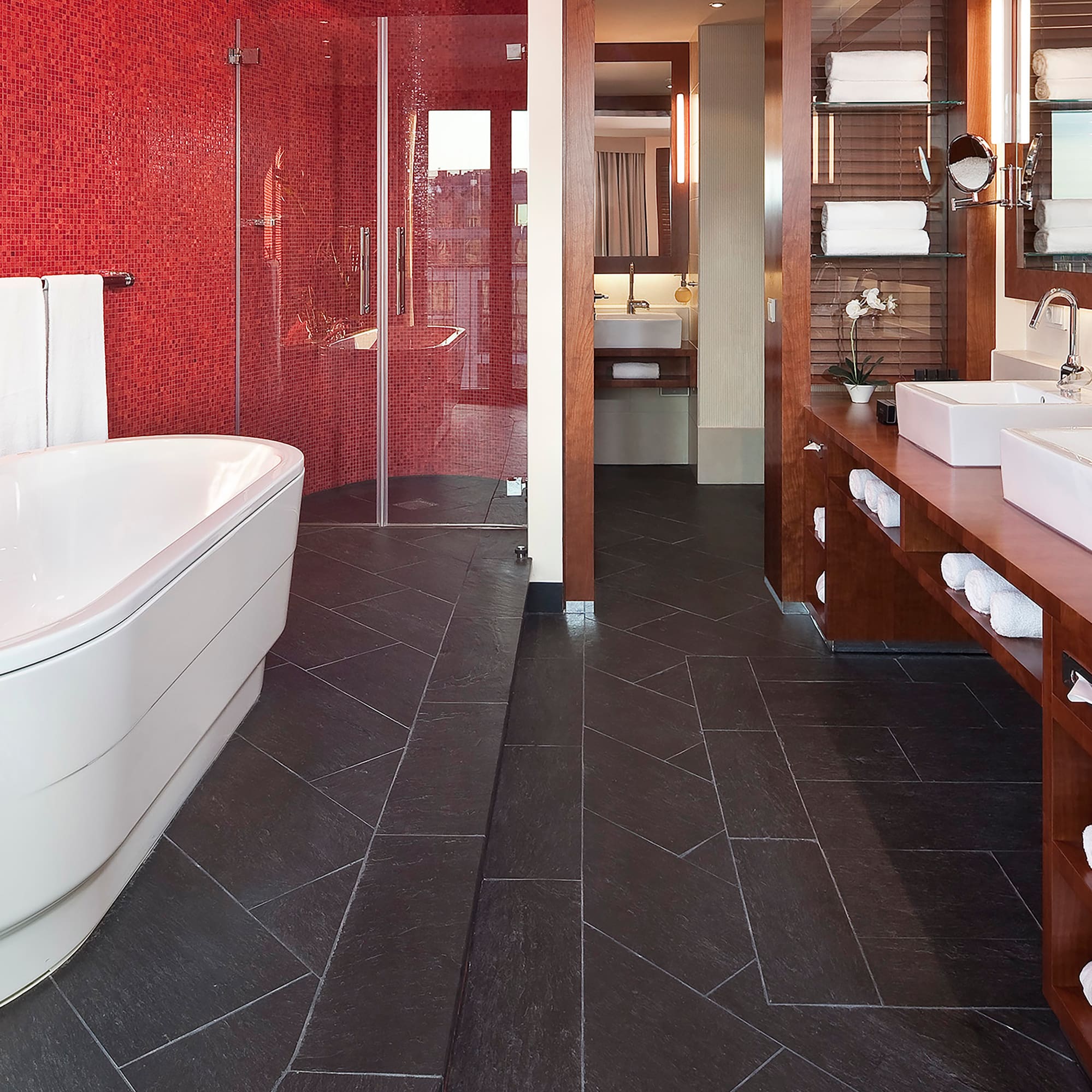 a bathroom with a red wall and a tub