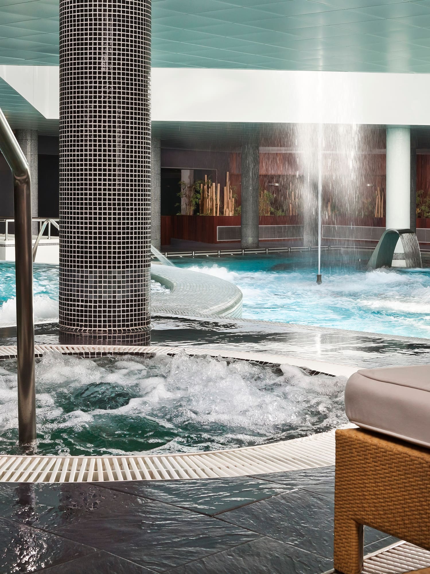 a pool with water jets and a white cushion