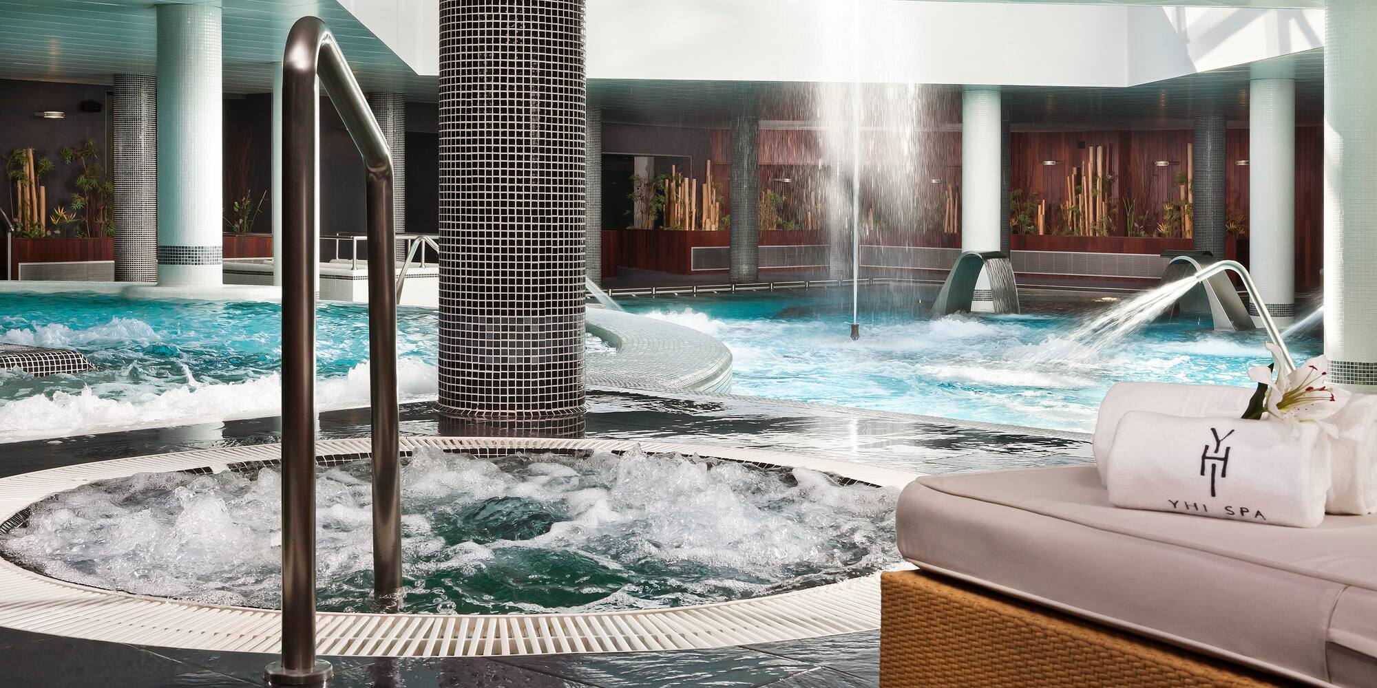 a pool with water jets and a waterfall