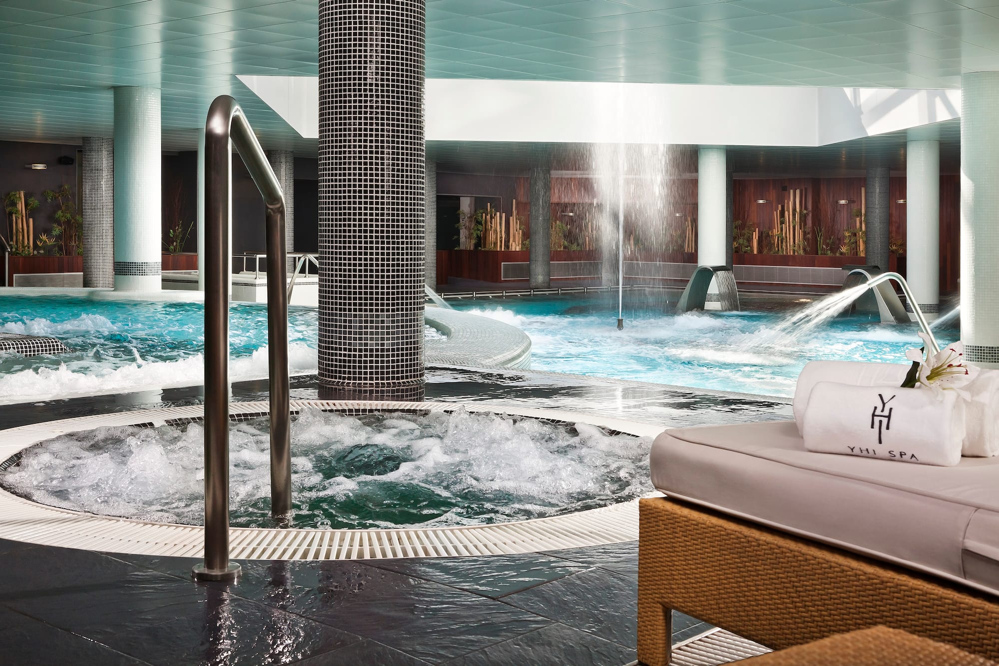 a pool with water jets and a waterfall