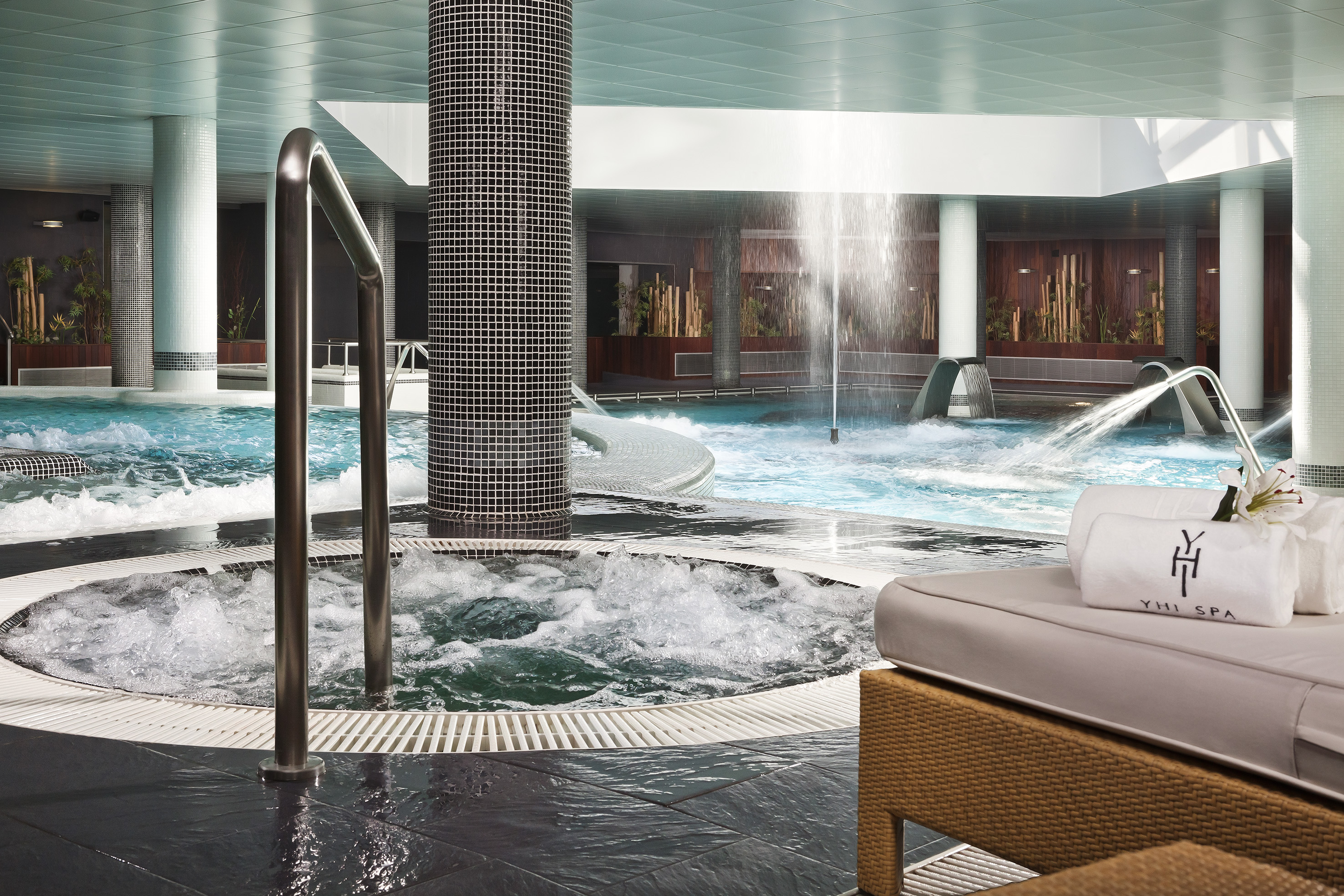 a pool with water jets and a waterfall