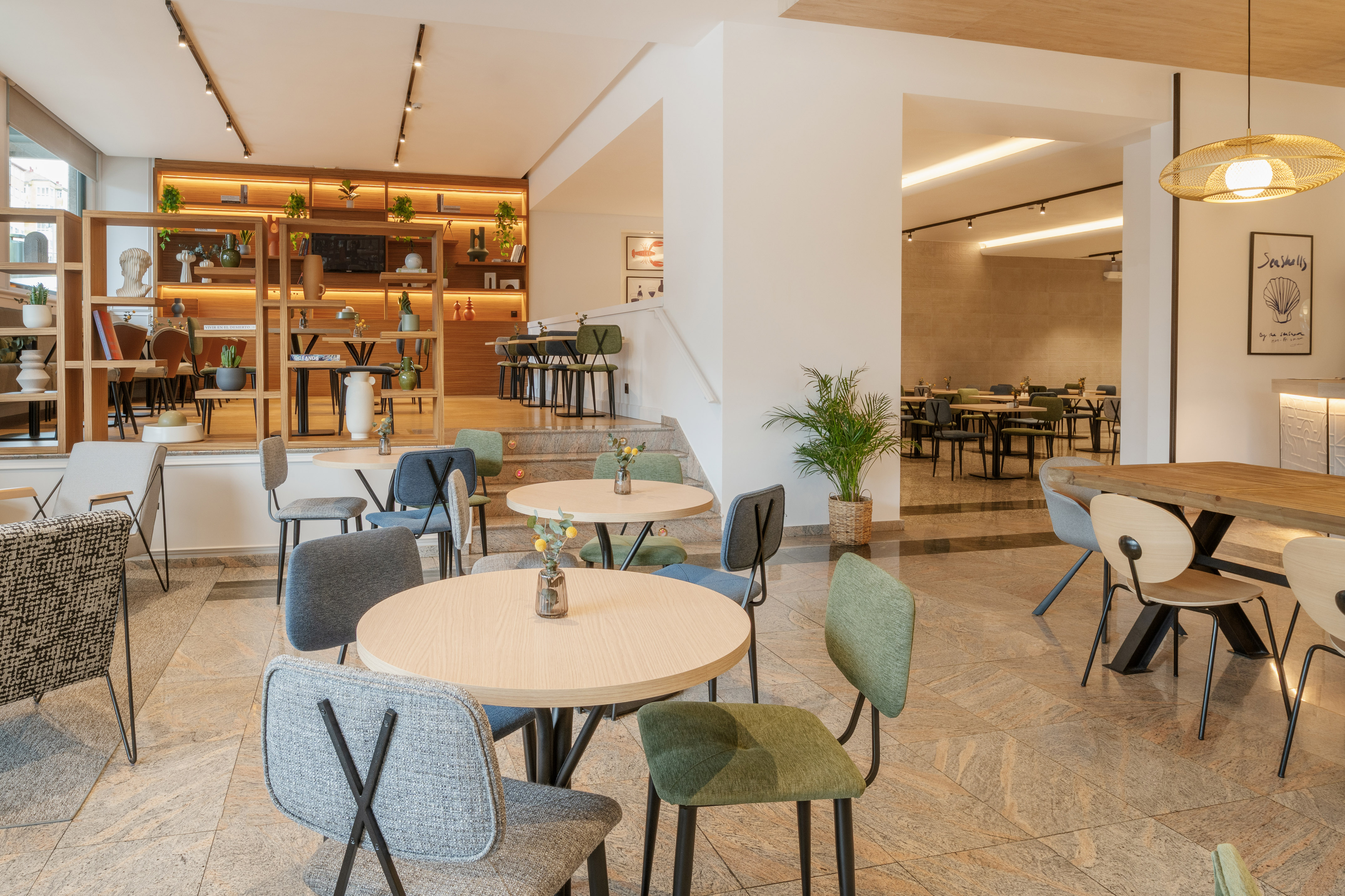 Modern hotel lounge cafe with round tables, colorful chairs, and stylish decor.