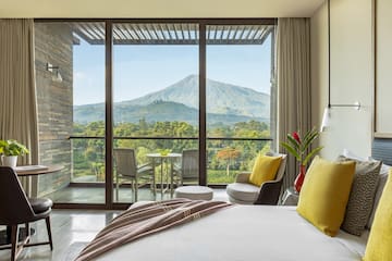 a bedroom with a view of mountains and trees