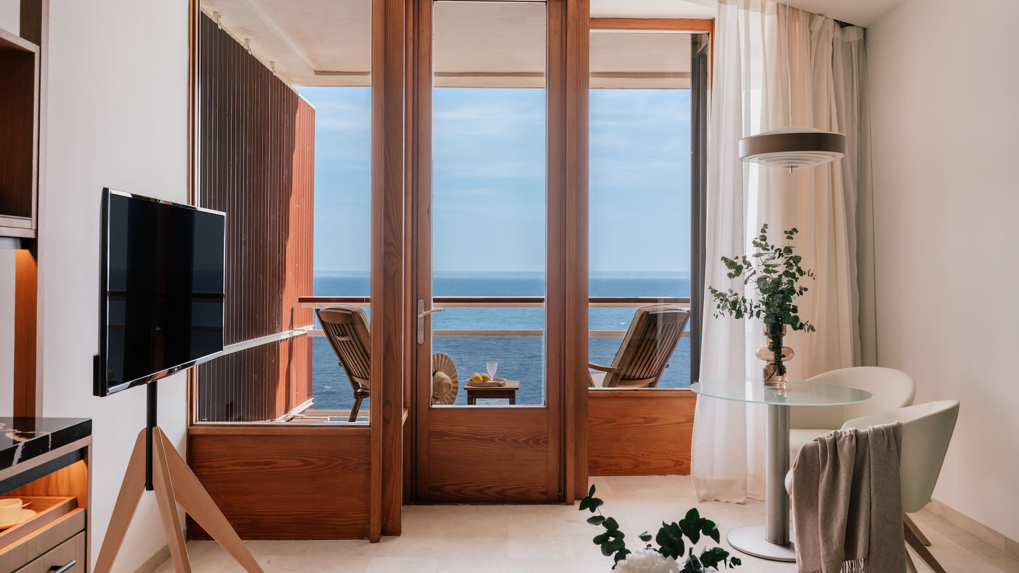 a room with a television and a view of the ocean