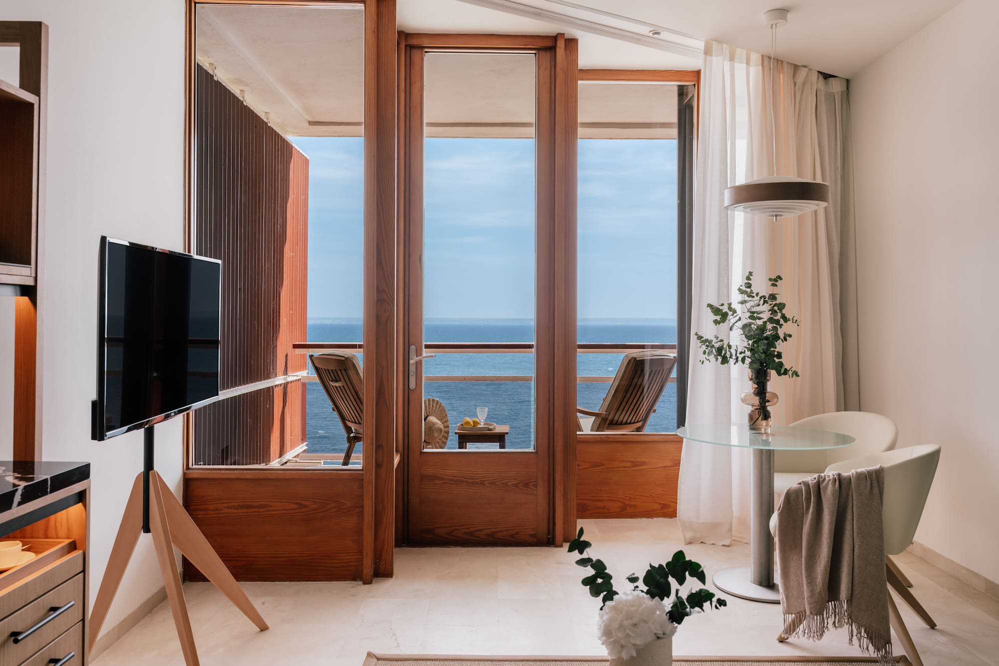 a room with a television and a view of the ocean