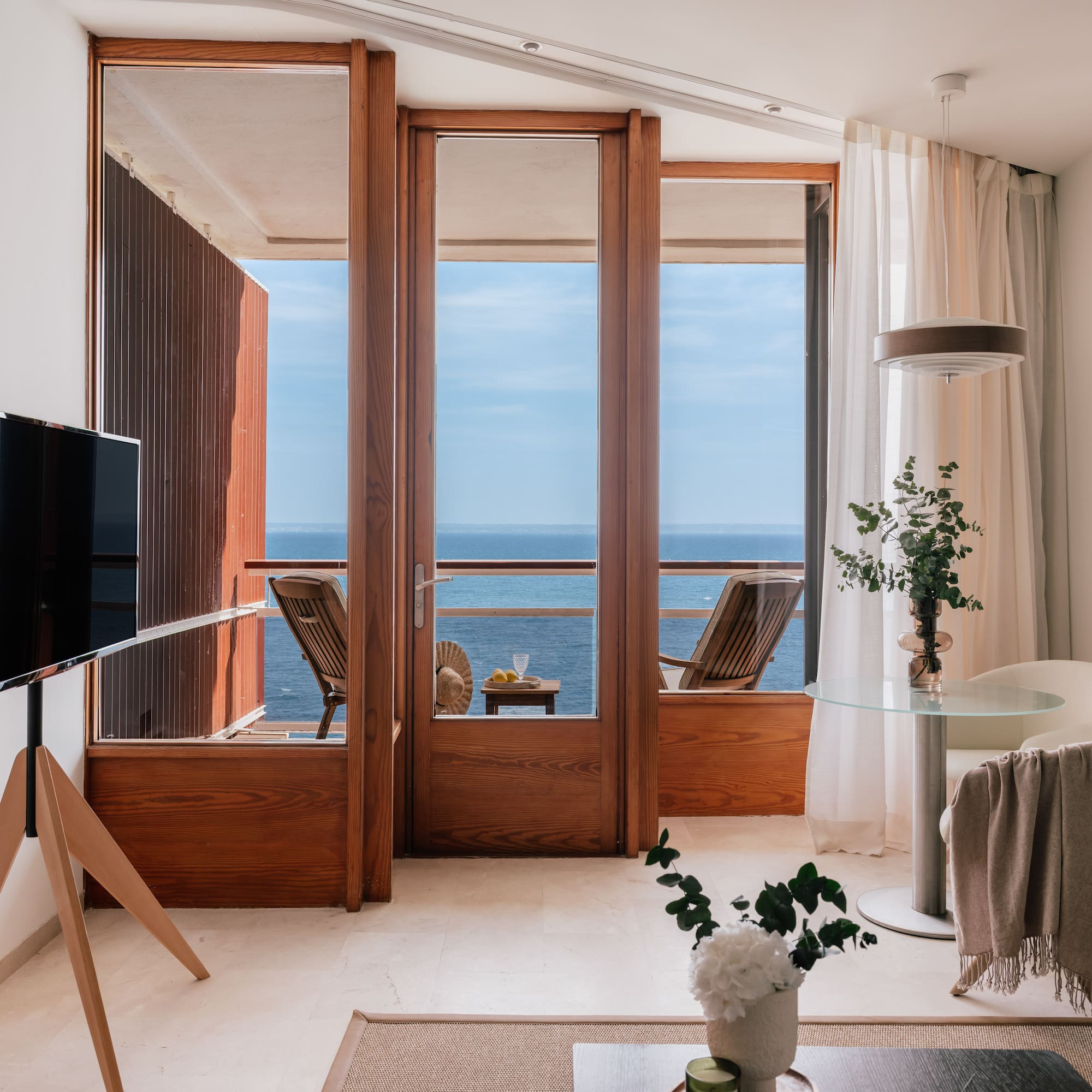 a room with a television and a view of the ocean
