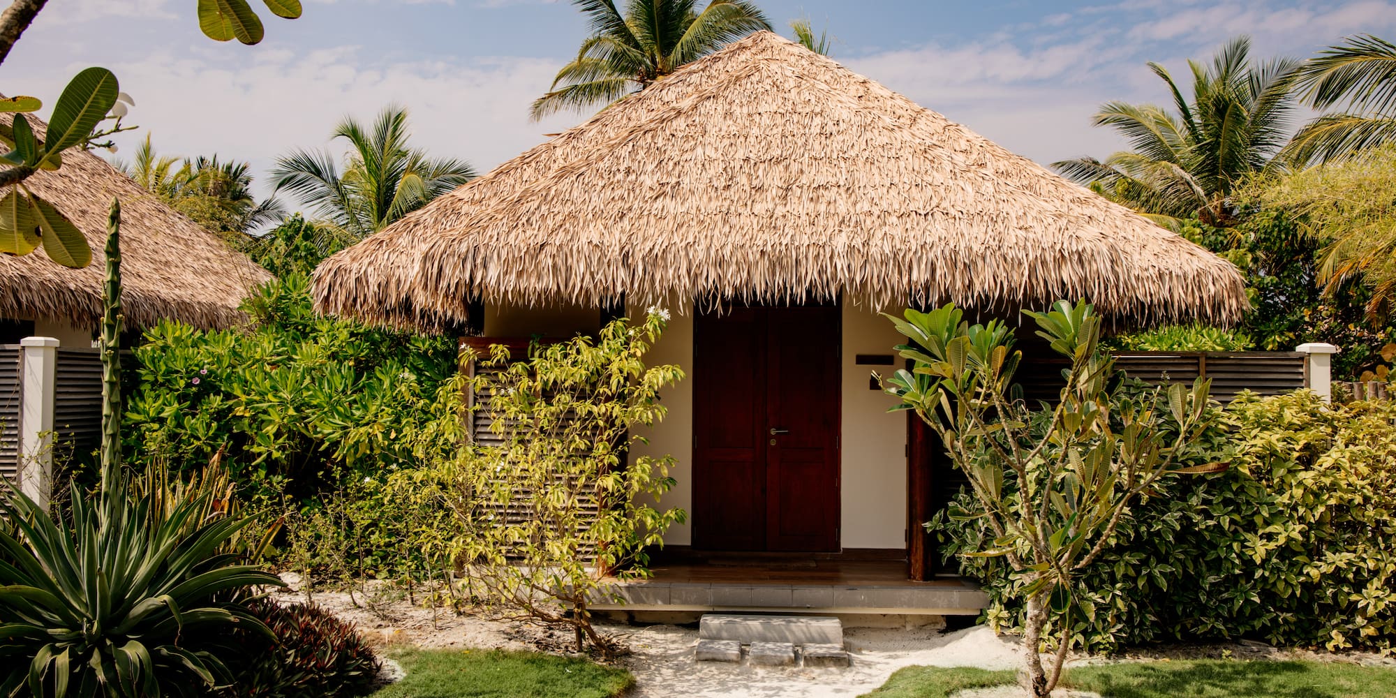 a small hut with grass roof and trees