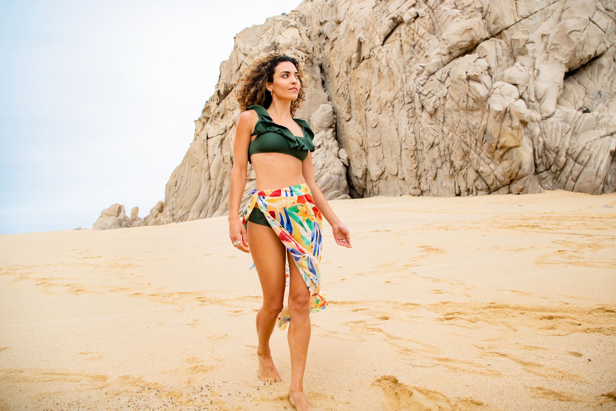 a woman in a garment and a skirt on a beach