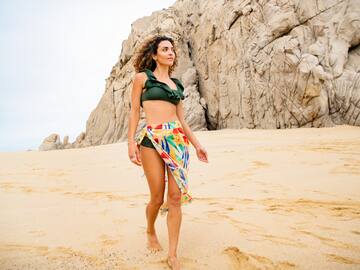 a woman in a garment and a skirt on a beach