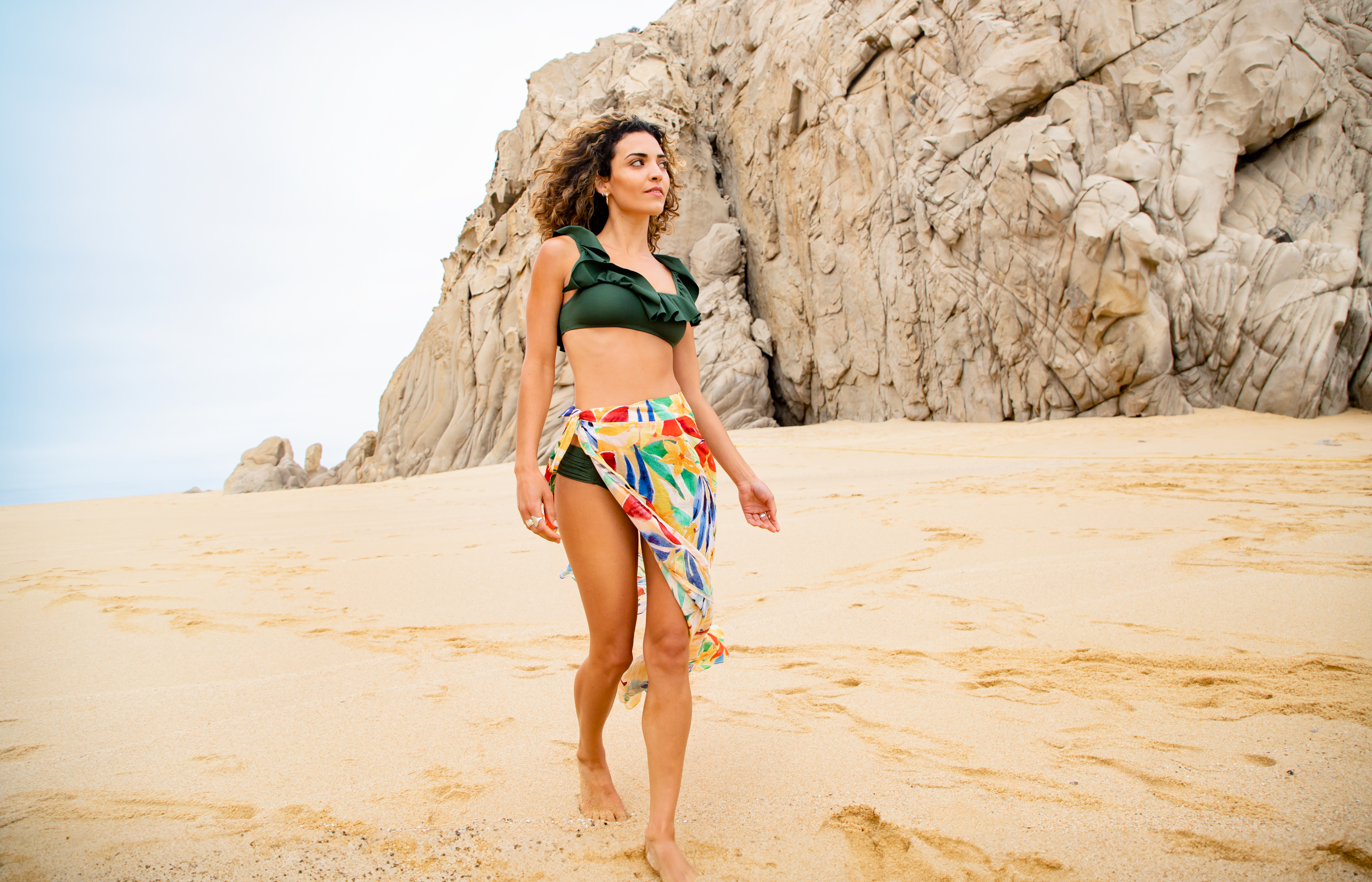 a woman in a garment and a skirt on a beach