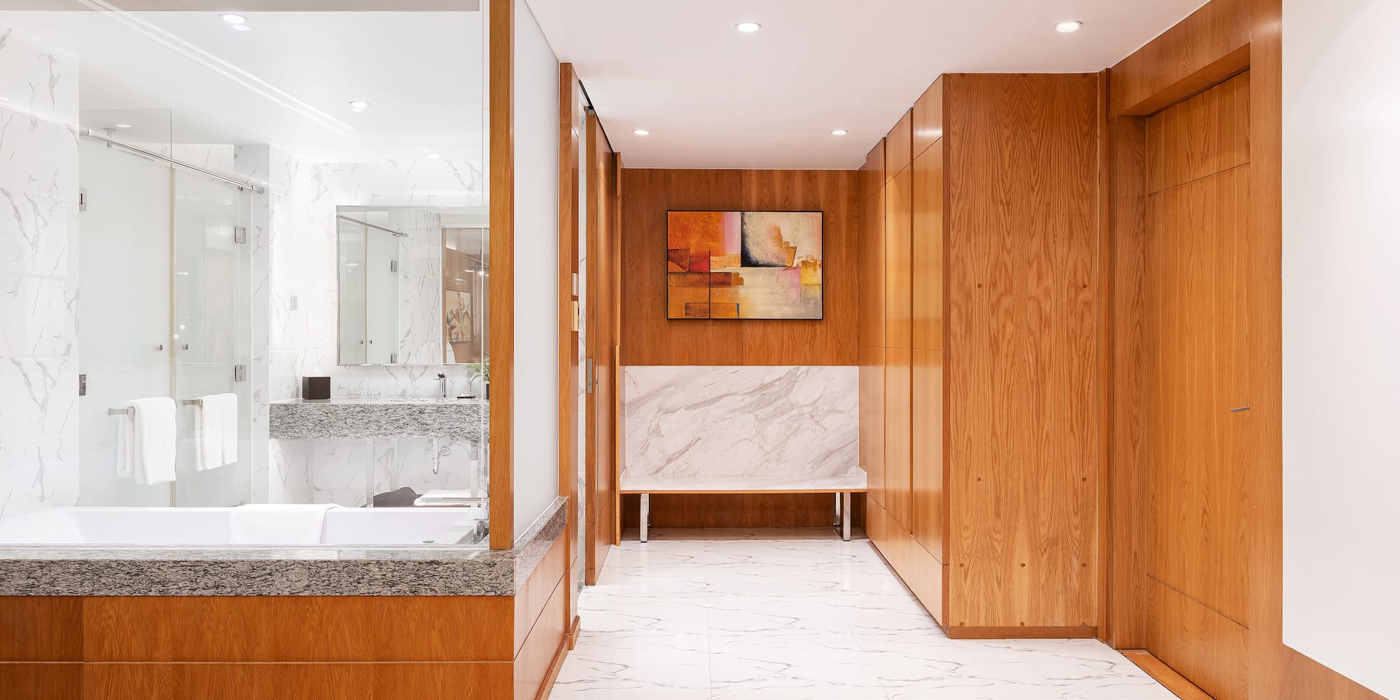 a bathroom with wood cabinets and marble floor
