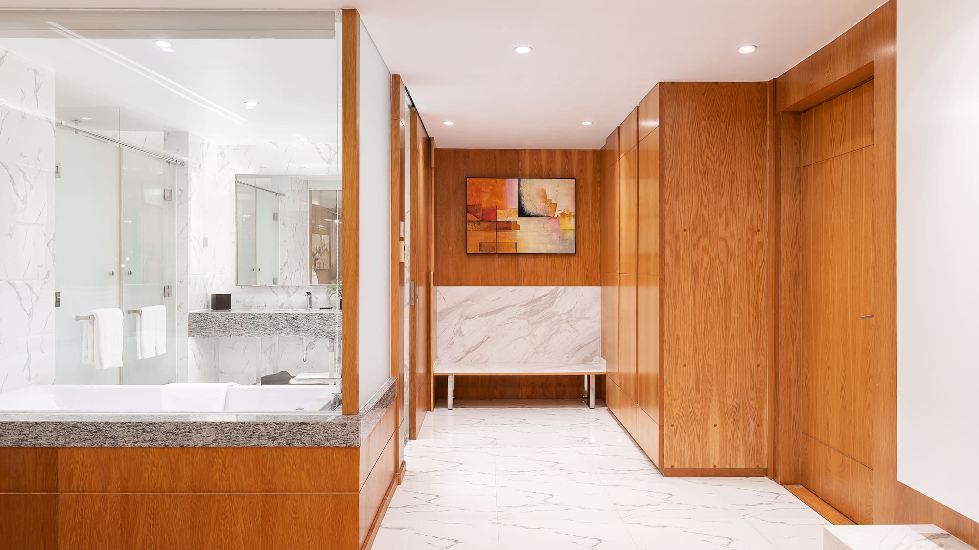 a bathroom with wood cabinets and marble floor